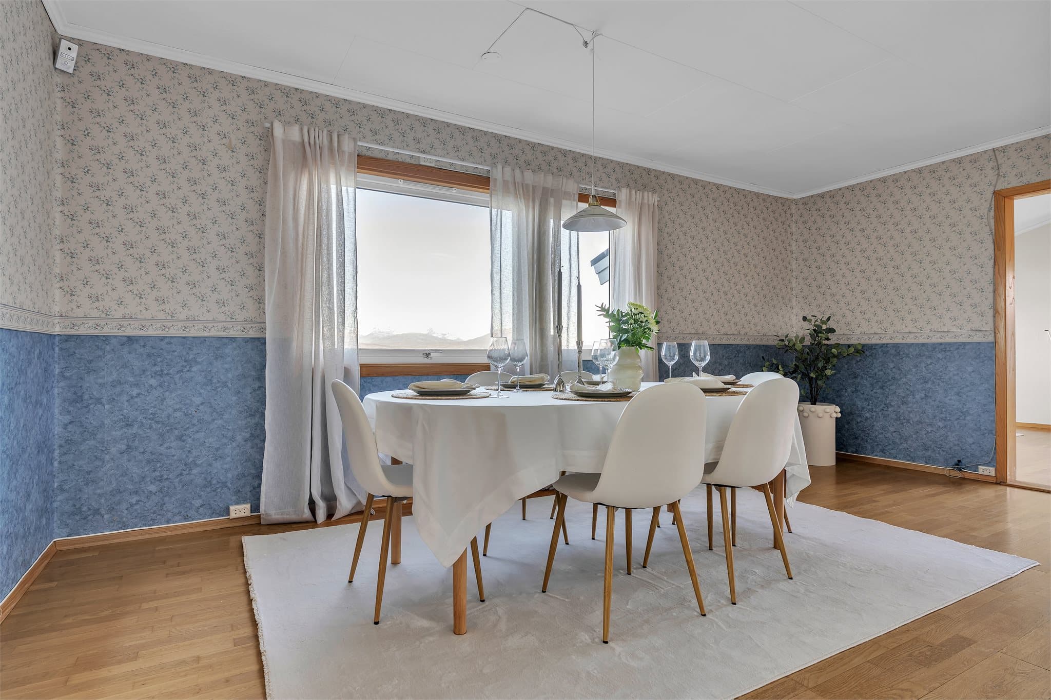Spisestuen har god plass til langbord for sosiale sammenkomster ved vinduet.