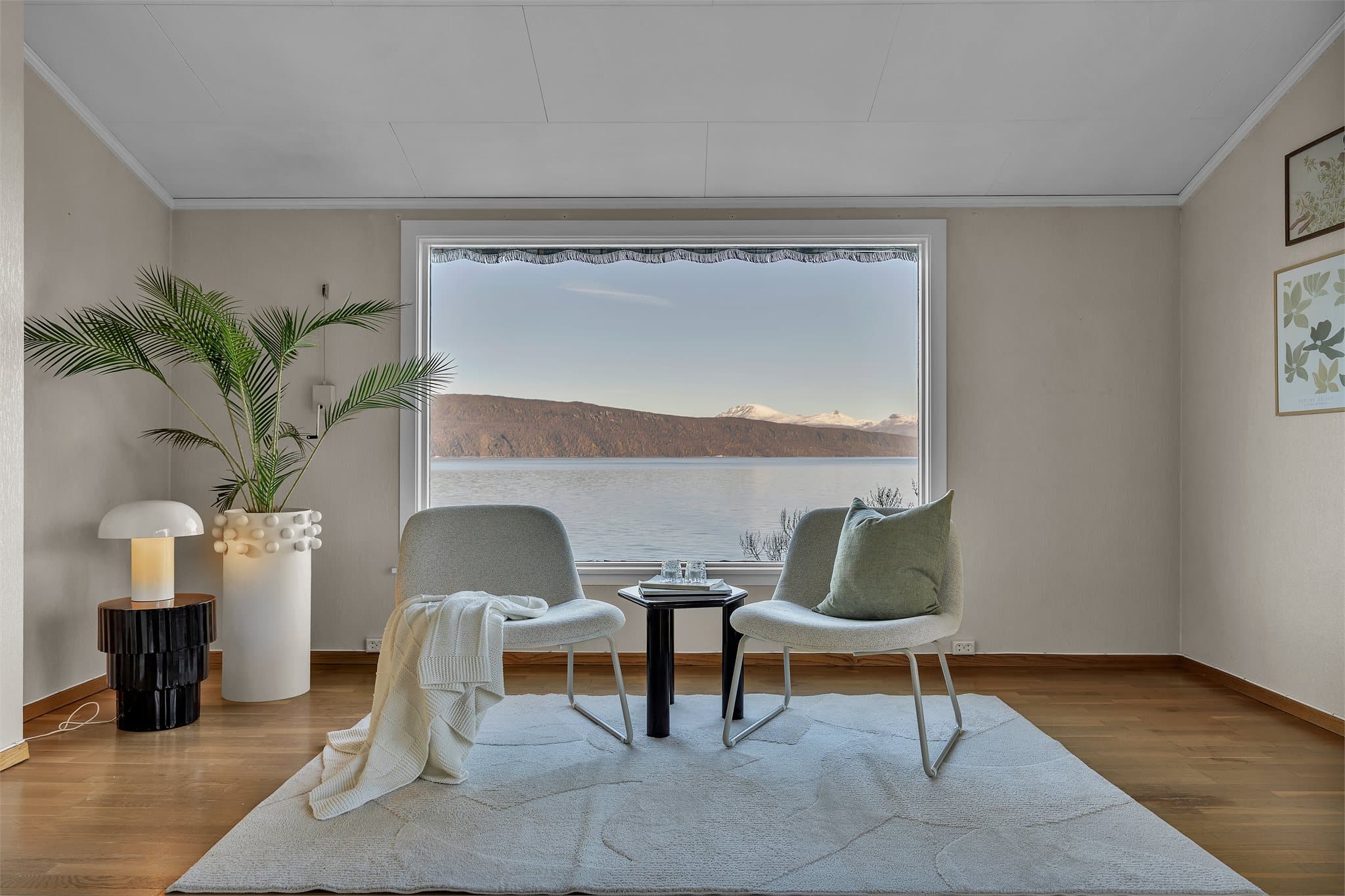 Utsikten mot snøkledde fjelltopper gir et vakkert bakteppe i stuen.
