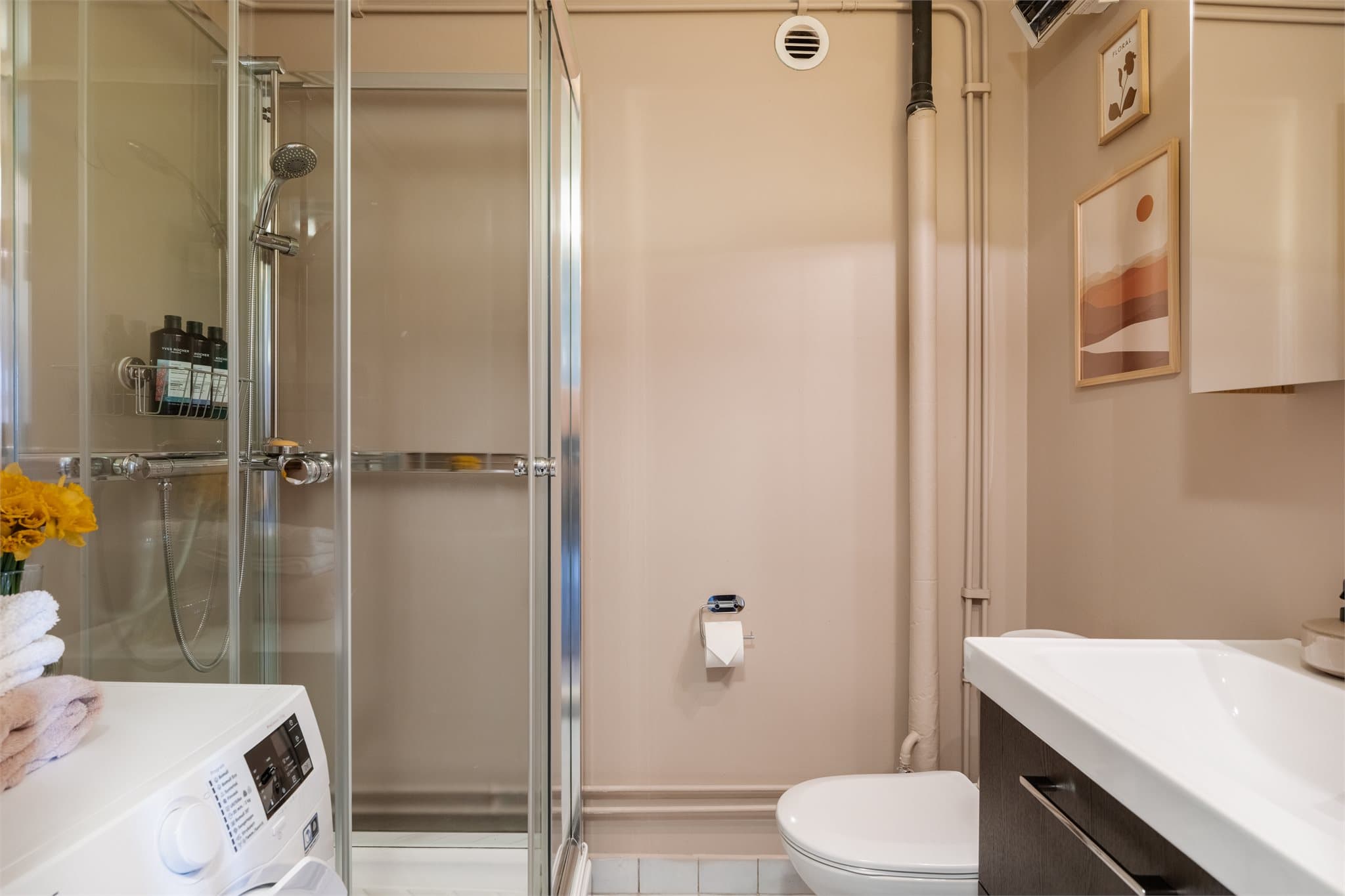 Bad i tilknytning til entréen som er overflateoppusset med nyere innredning som servant, speilskap og et dusjkabinett. Rommet er fra byggeår har behov for oppgradering