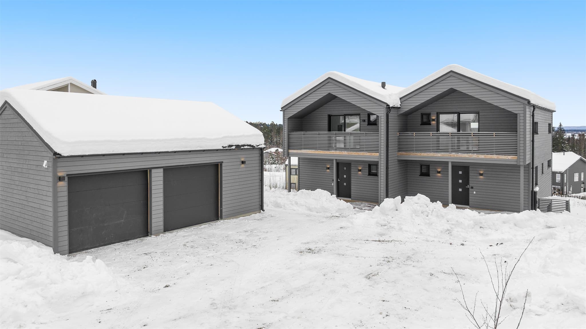 Inngangsside. Det disponeres en garasje pr. tomannsbolig samt sportsbod i tilknytning