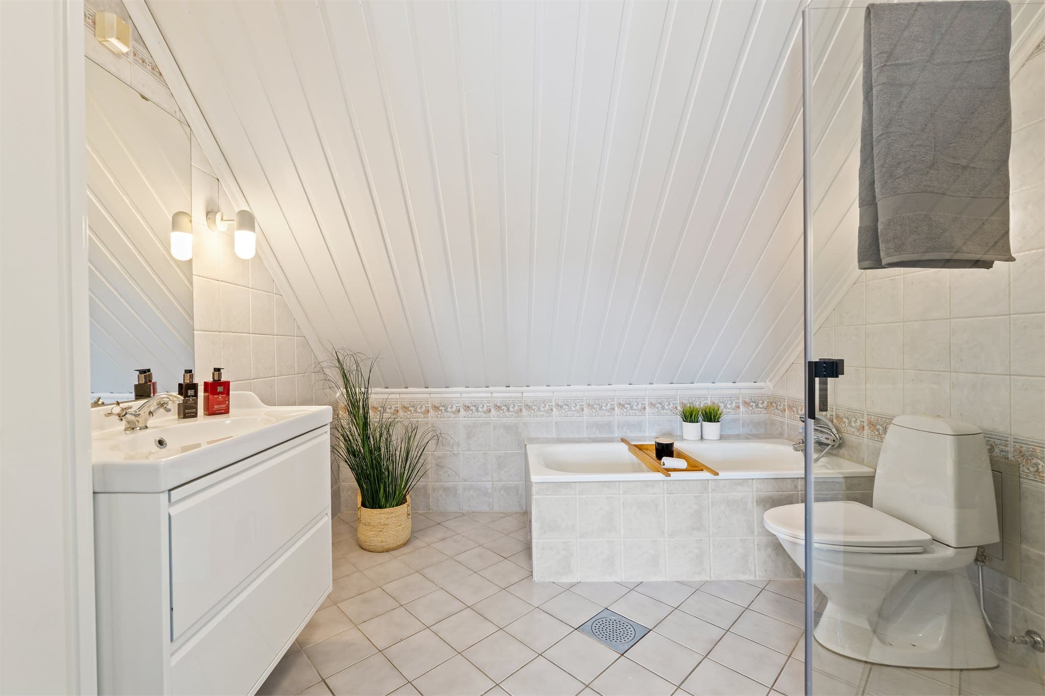 Badet er godt utstyrt med både dusjhjørne med glassdører, veggmontert dusjarmatur samt badekar med dusj- og badekararmatur. Videre har rommet gulvstående toalett.