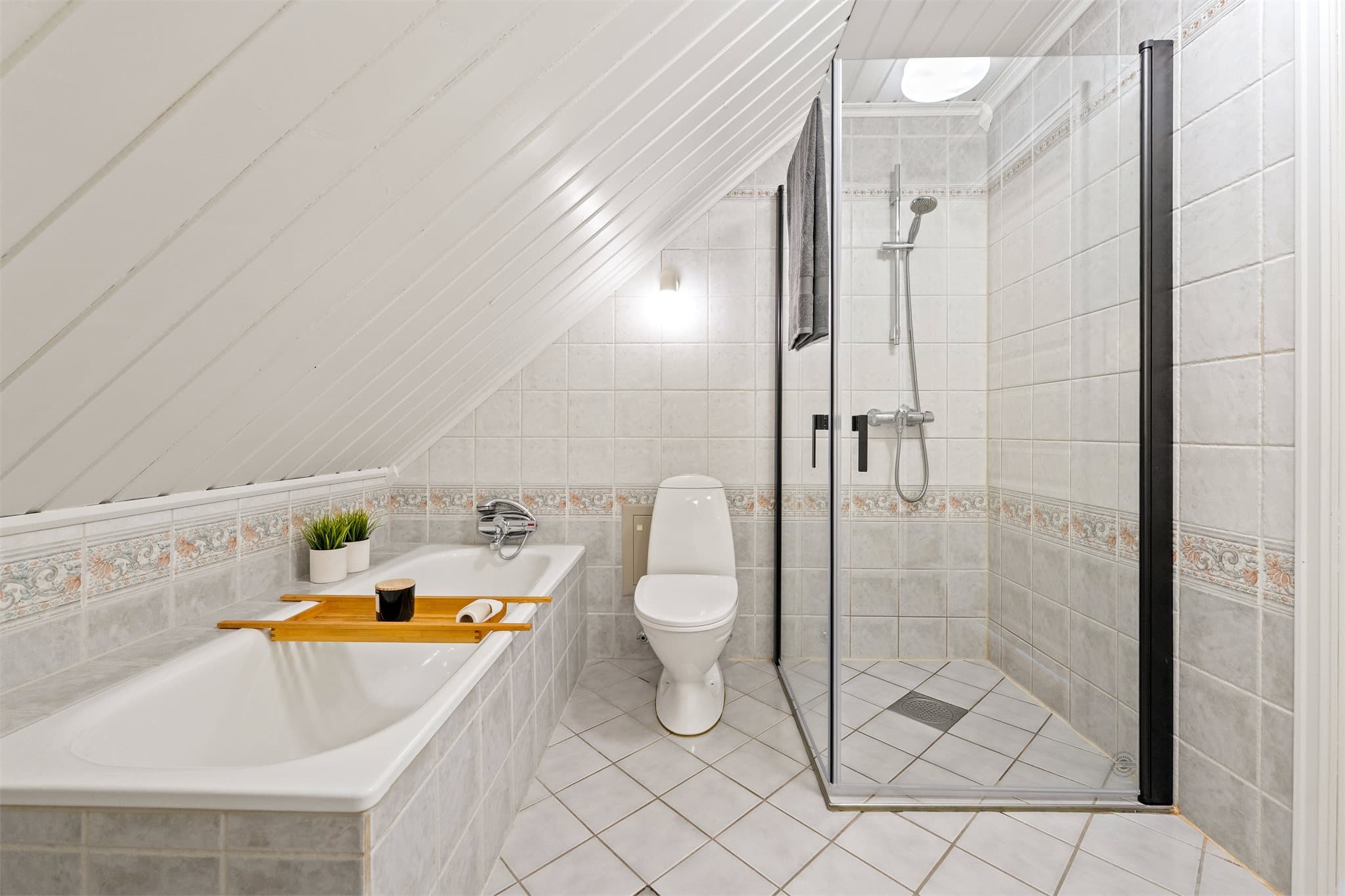 Innredningen består av et moderne, vegghengt servantskap med skuffer og ovenpåliggende servant med to-greps armatur.