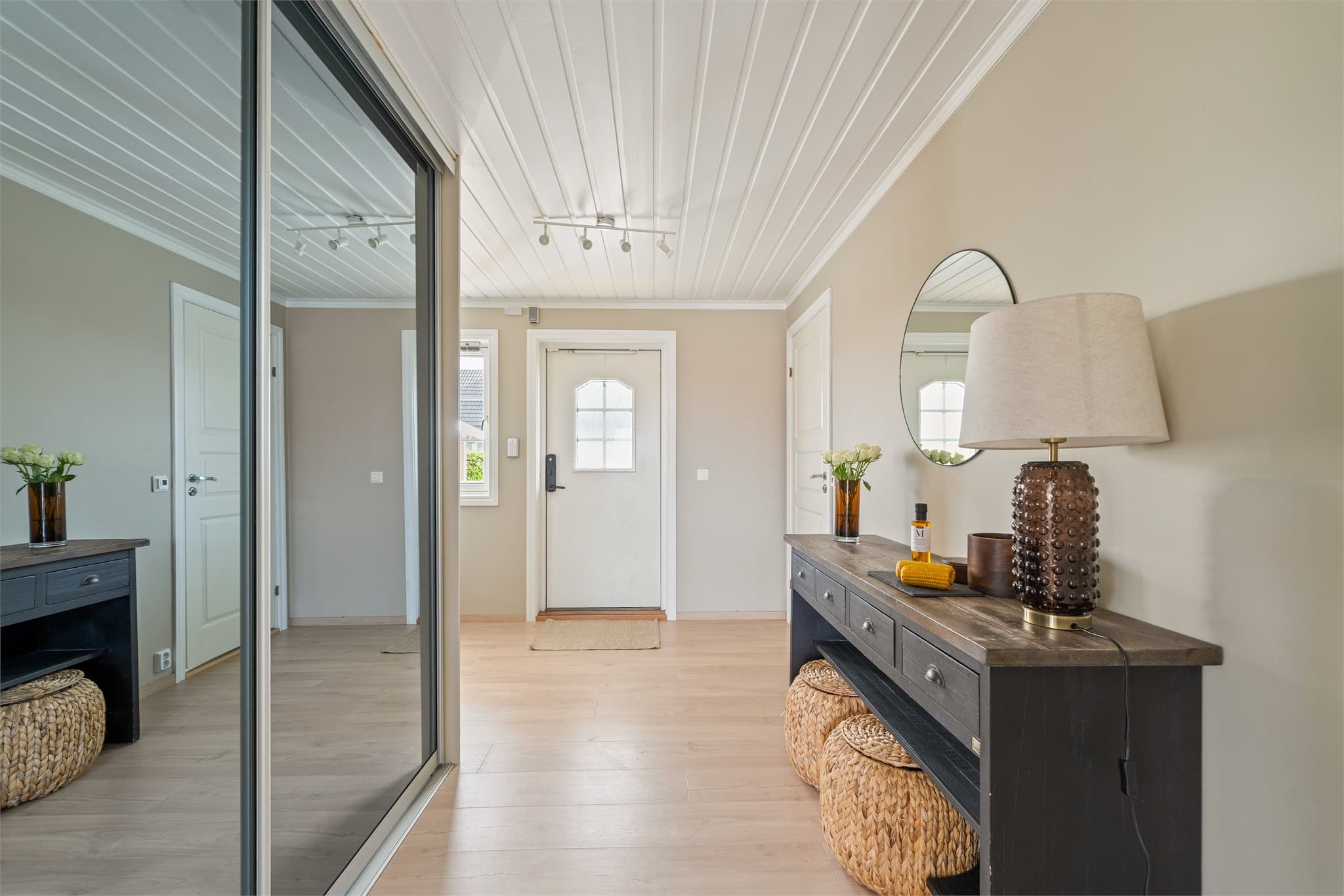 Boligen ønsker velkommen med en lys og romslig entré, malt i en delikat beigetone med hvit himling som gir et tidløst og elegant preg.