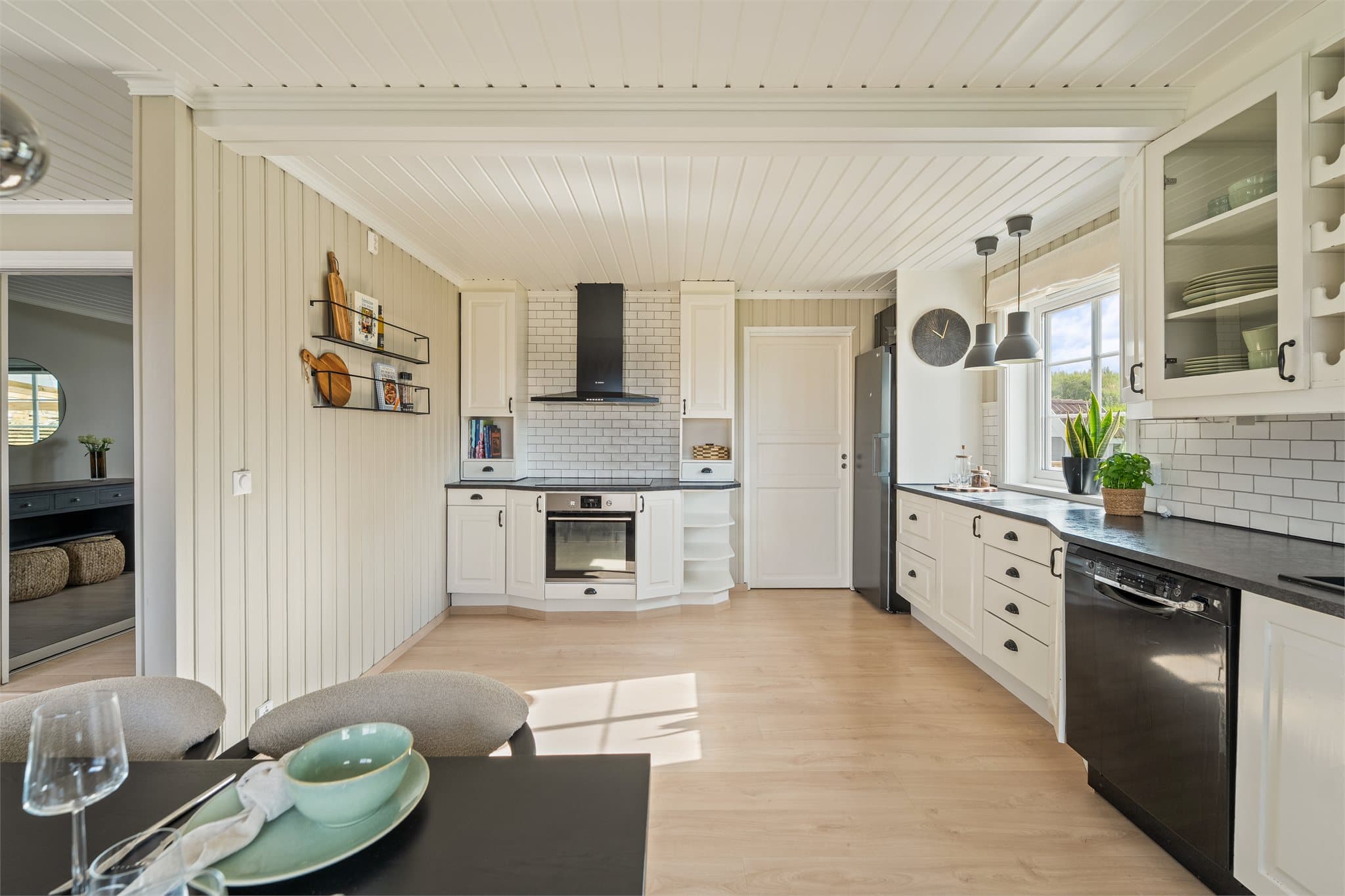 Kjøkkenet er utstyrt med frittstående kjøleskap, oppvaskmaskin og vinskap, samt integrert komfyr, nedfelt platetopp og veggmontert ventilator.