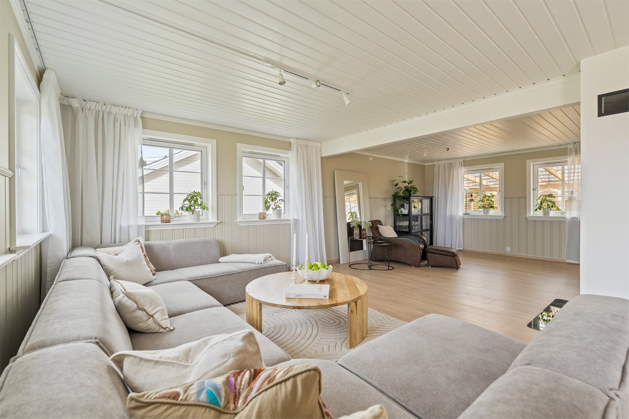 Stuen ligger i delvis åpen løsning mot kjøkkenet, noe som skaper en sosial og praktisk planløsning med god plass til både sofagruppe og spiseplass.