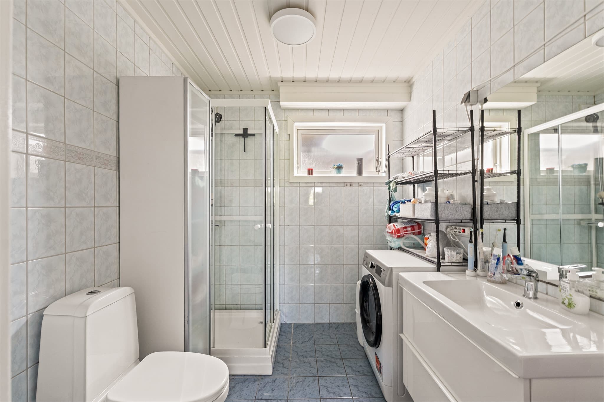 Baderommet er fra byggeåret 1999 og har flislagt gulv med behagelig gulvvarme, utstyrt med vegghengt servantskap, dusjkabinett og gulvstående toalett samt opplegg for vaskemaskin.