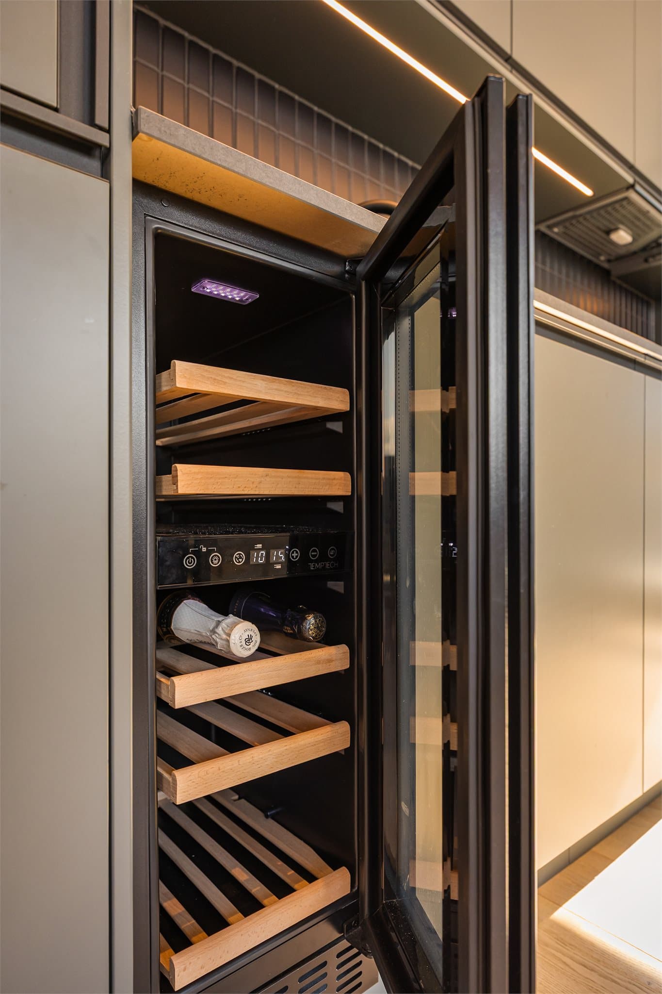 Innredningen har integrert vinskap, koketopp, stekeovn, oppvaskmaskin og kombiskap.