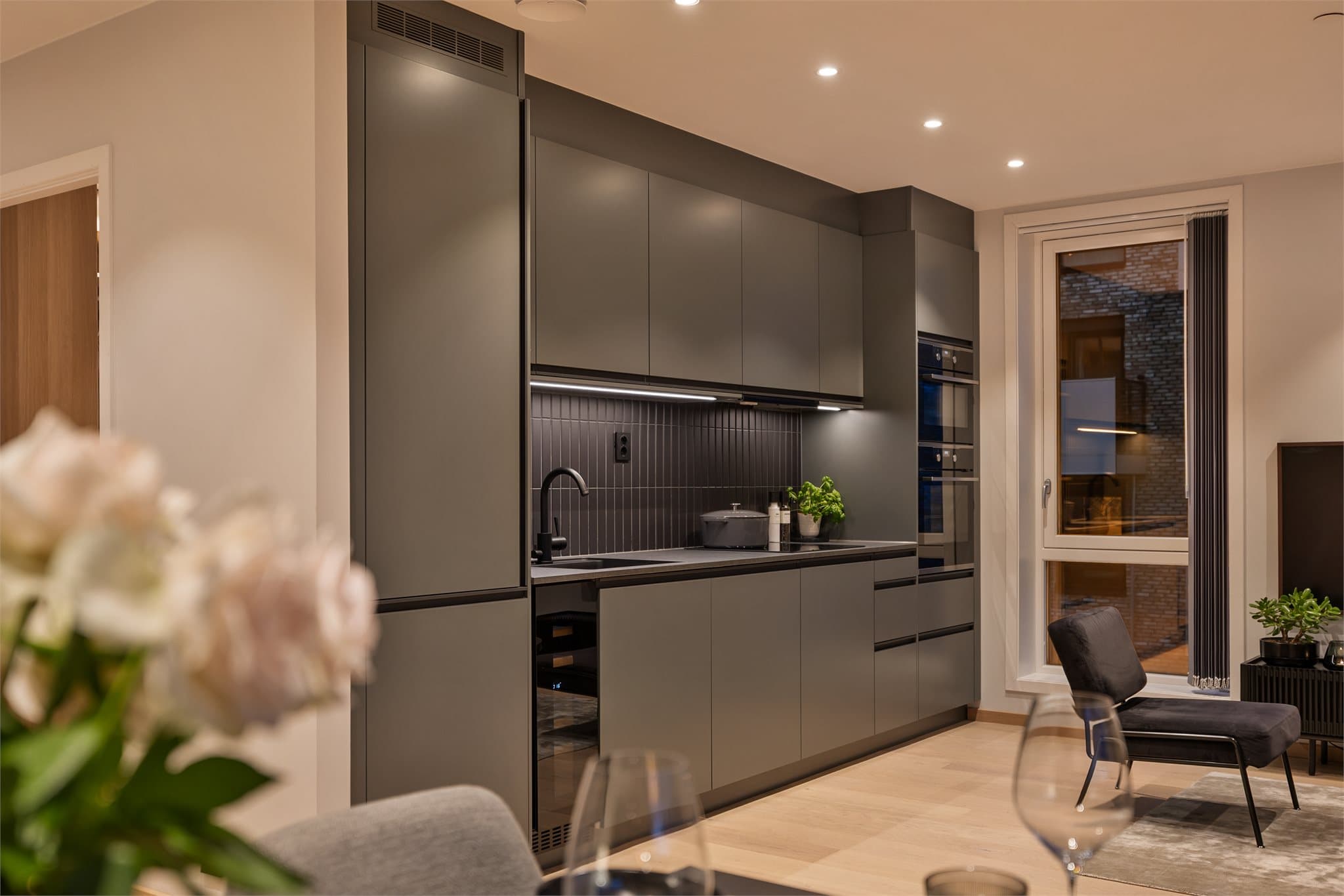 Kjøkkenet har slette fronter og laminert benkeplate med nedfelt oppvasskum.