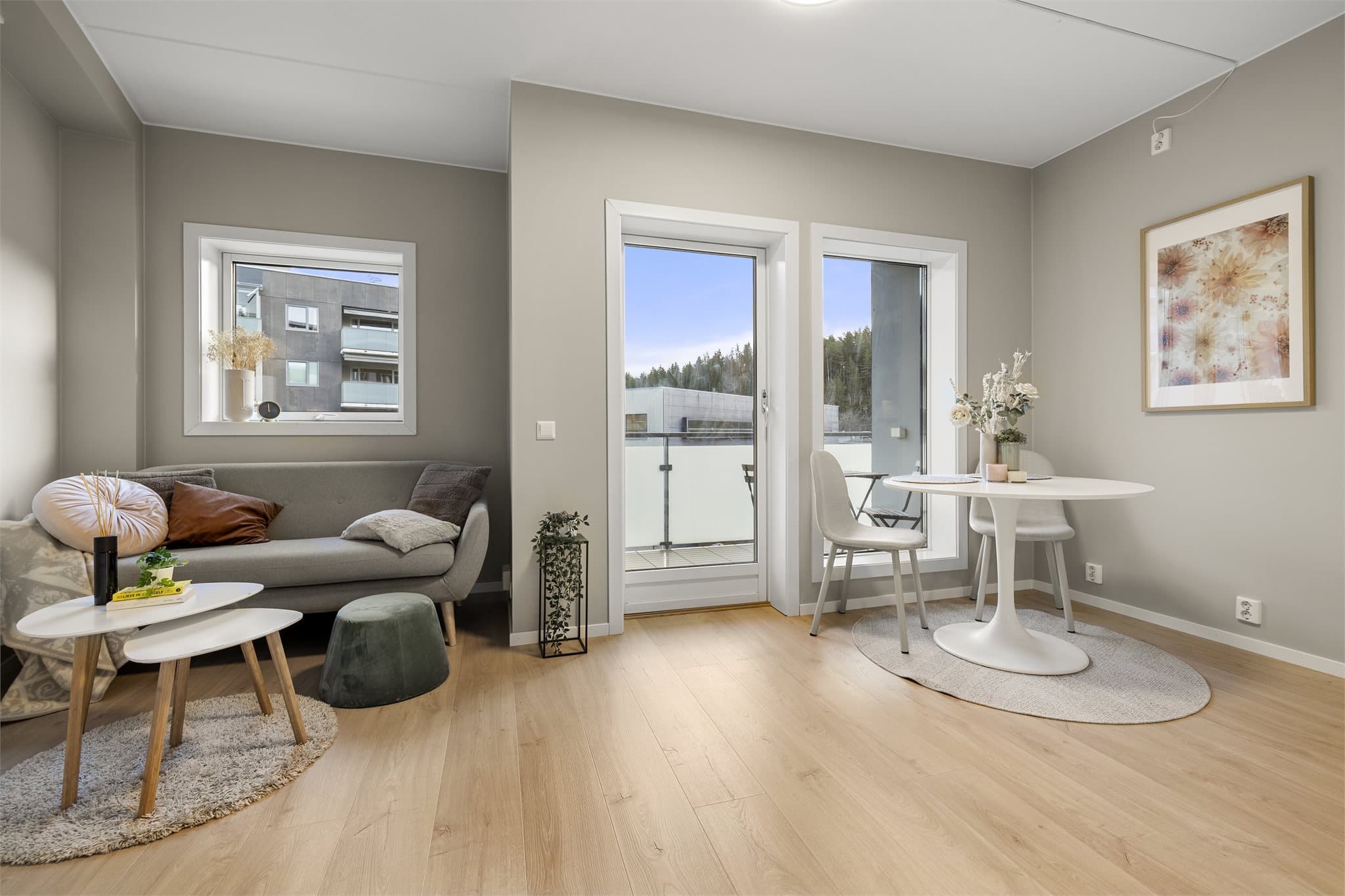 Lys og innbydende stue med store vindusflater og god plass til sofagruppe.