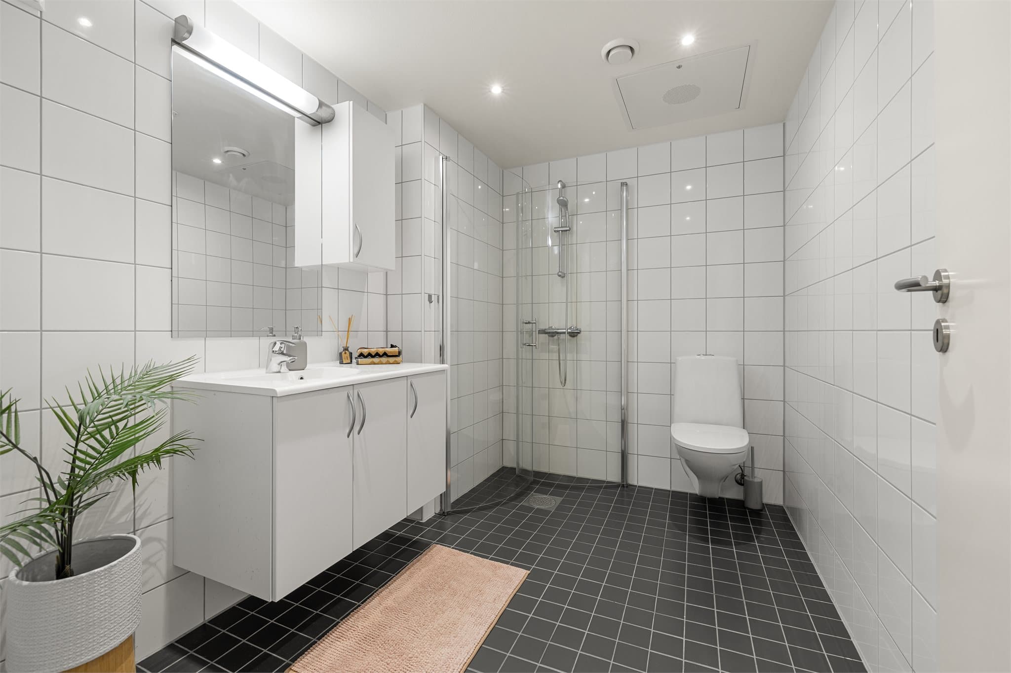 Flislagt bad i tidløst design med gulvvarme.