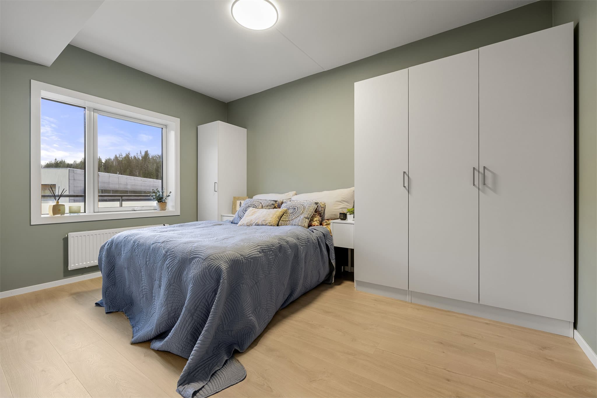 Romslig soverom med plass til en dobbelseng og nattbord.