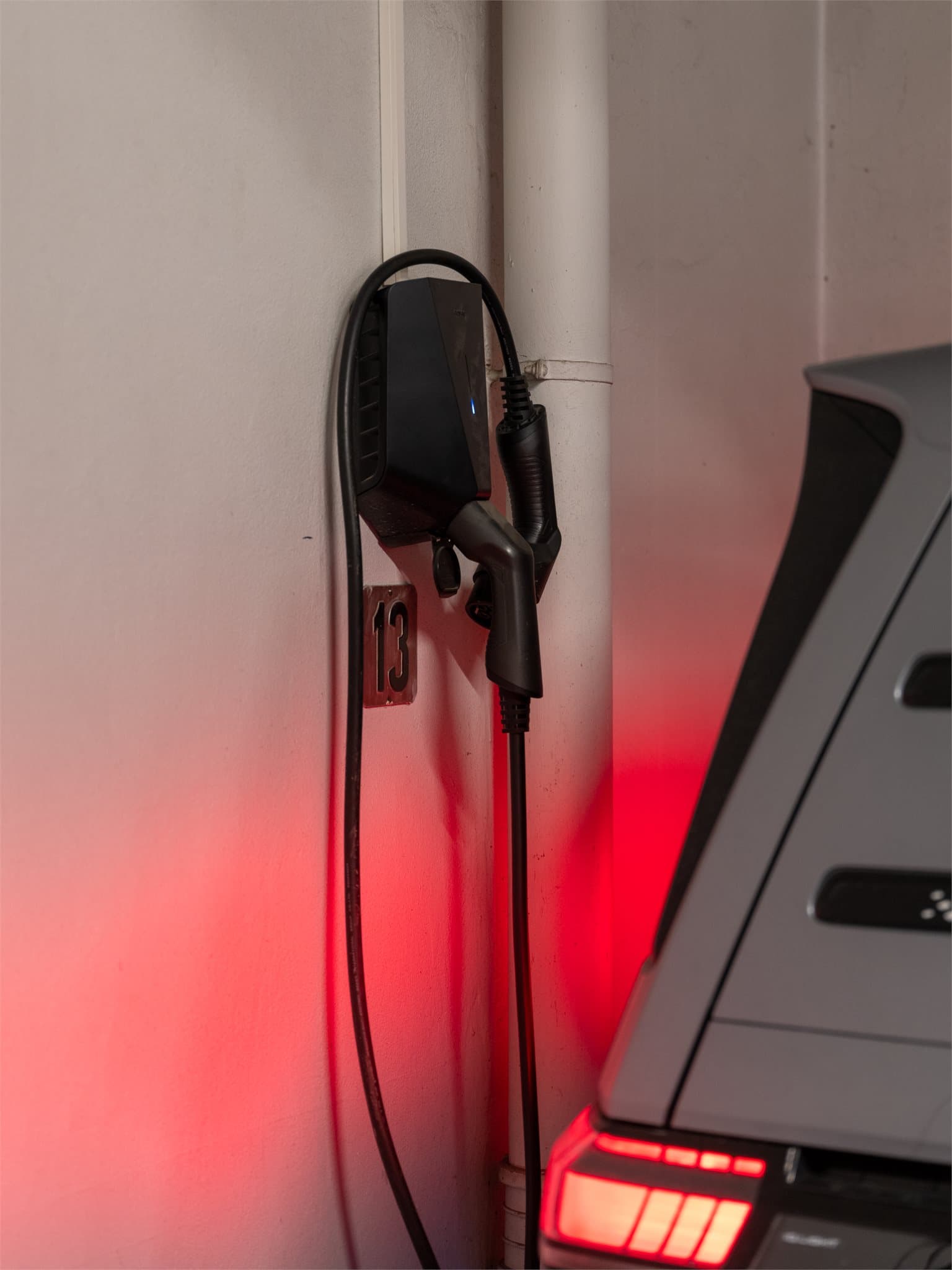 Det er installert lader for elbil ved parkeringsplassen.