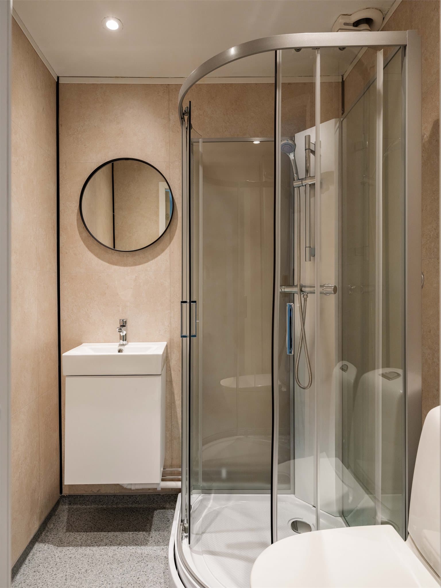 Badet er oppgradert i nyere tid og fremstår moderne med sandfargede vegger og stilrene, sorte detaljer.