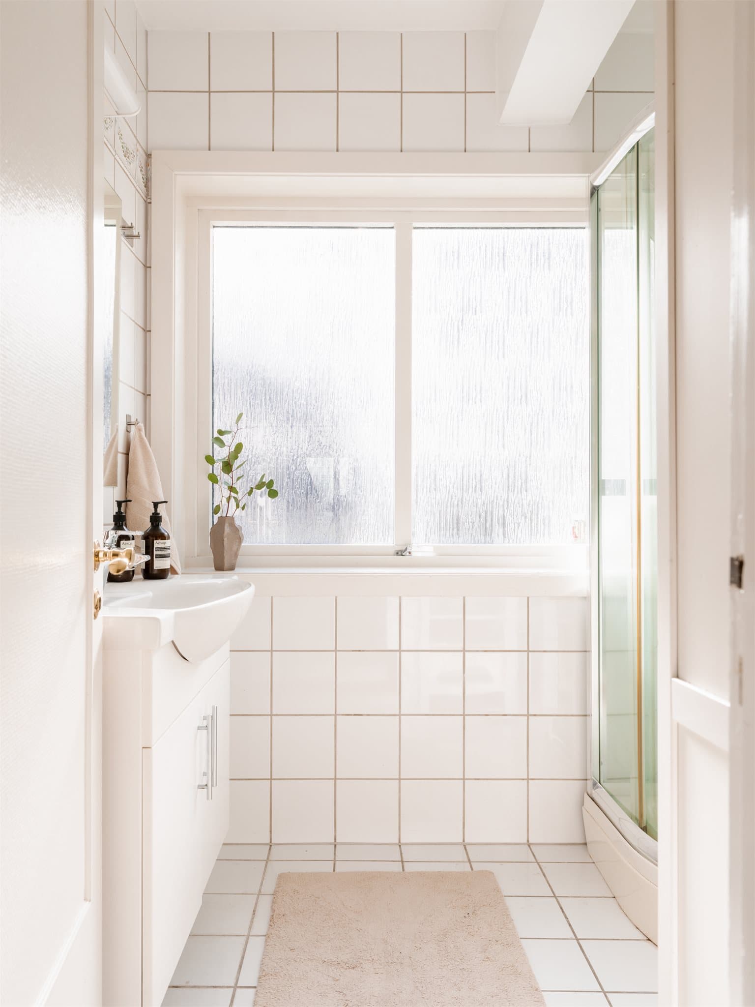 Leiligheten har et flislagt bad med servantinnredning, speil og dusjkabinett. Opplegg for vaskemaskin.