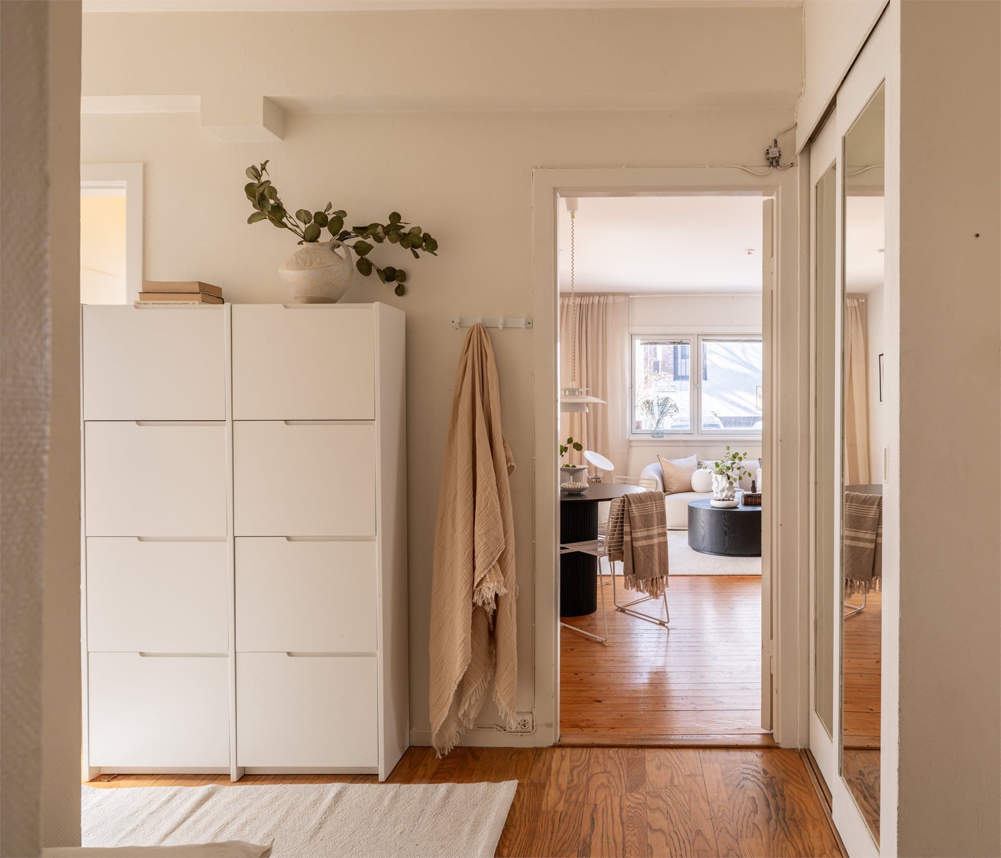 Entréen gir et godt førsteinntrykk og har plass til oppbevaringsløsninger for yttertøy og sko i bl.a. en spesialbygd skyvedørsgarderobe.