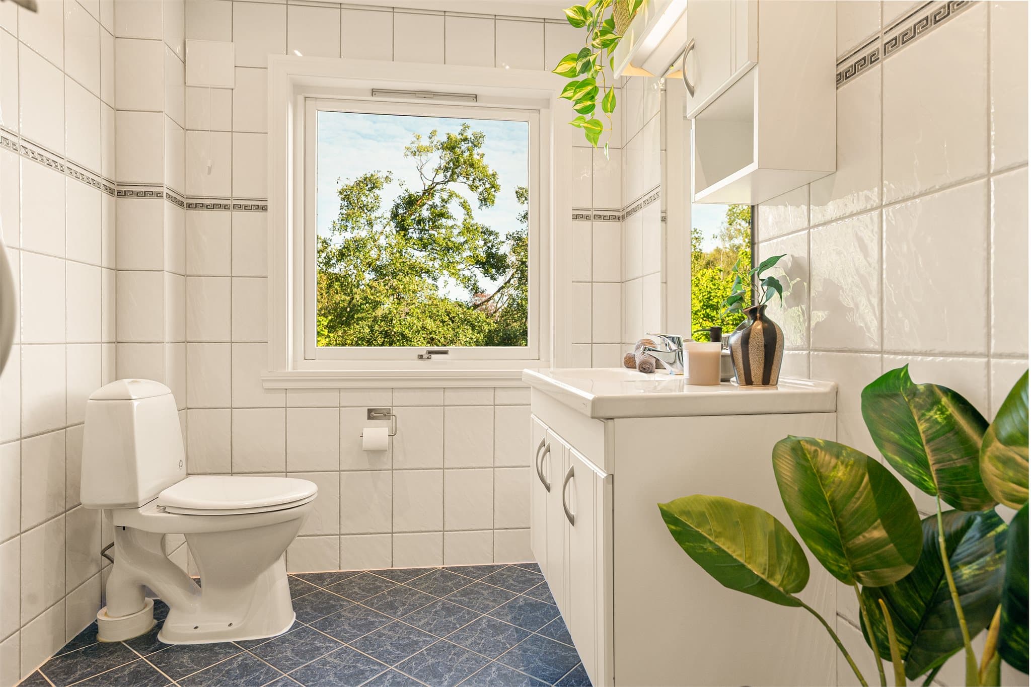 - Badet måler 4,4 m² og har fliser på gulv og vegger -