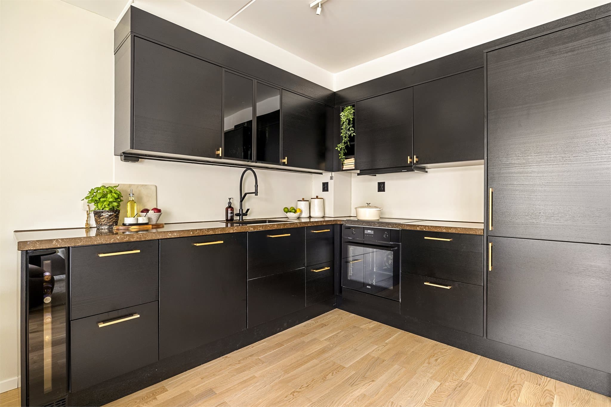 Kjøkkenet har innredning med glatte, moderne fronter. Eget vinskap er en fin detalj for deg som setter pris på gode flasker.