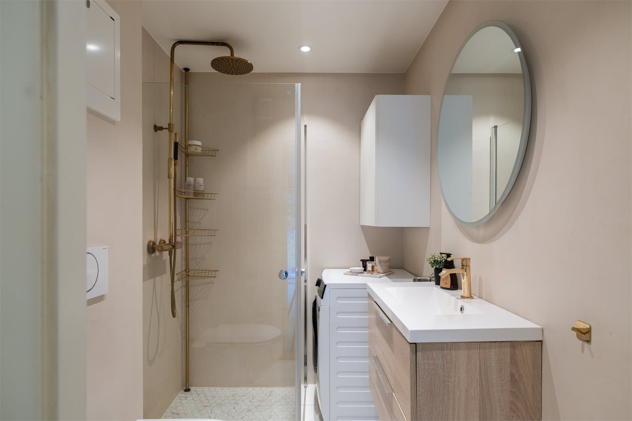 Stilrent bad fra 2022 med lyse overflater, delikate materialvalg og varme i gulvet.