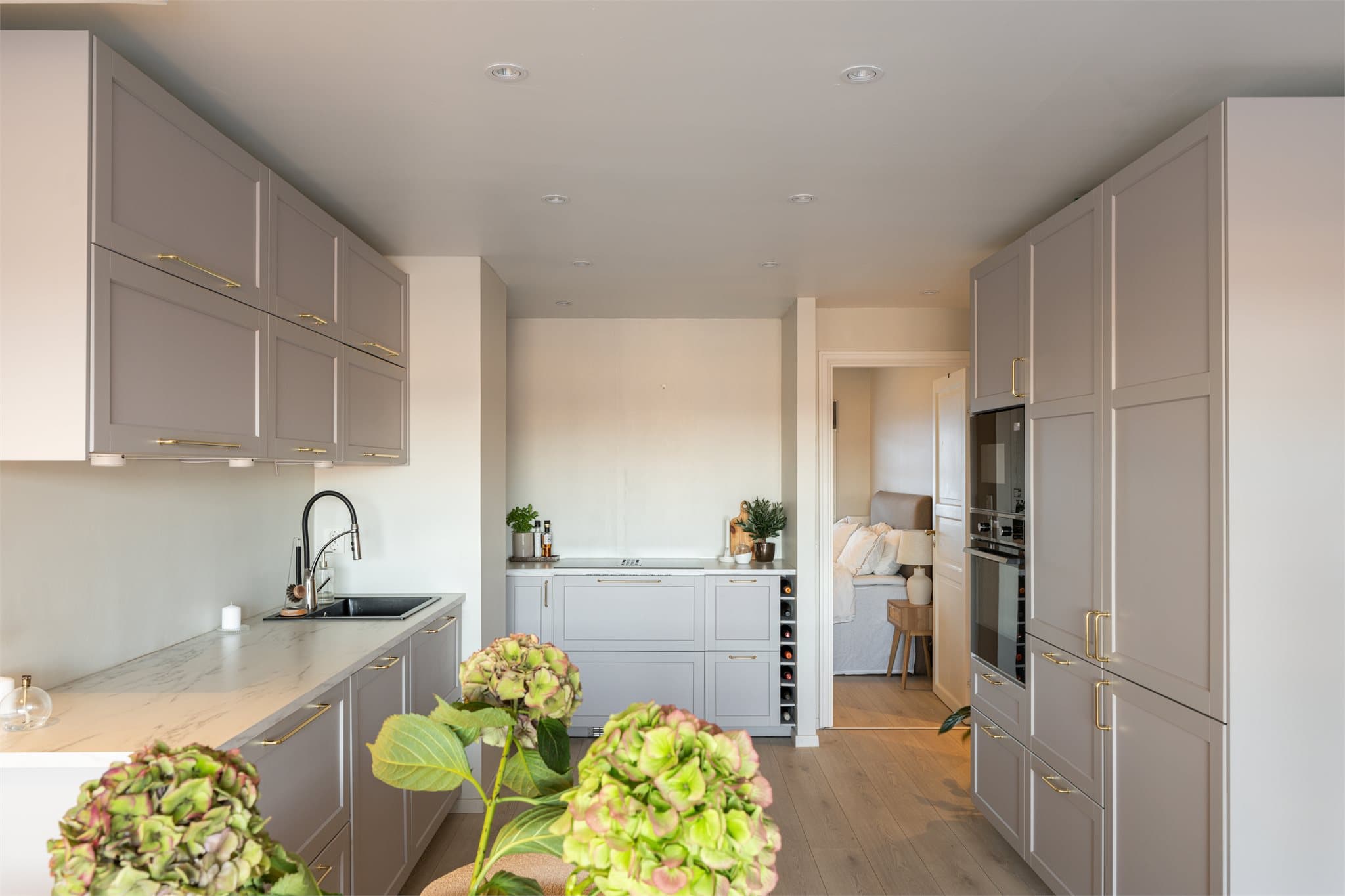 Et komplett kjøkken med alt du trenger av hvitevarer som: Oppvaskmaskin, kjøl- og fryseskap, stekeovn og mikrobølgeovn i høyden samt en lekker induksjonstopp med innfelt vifte.