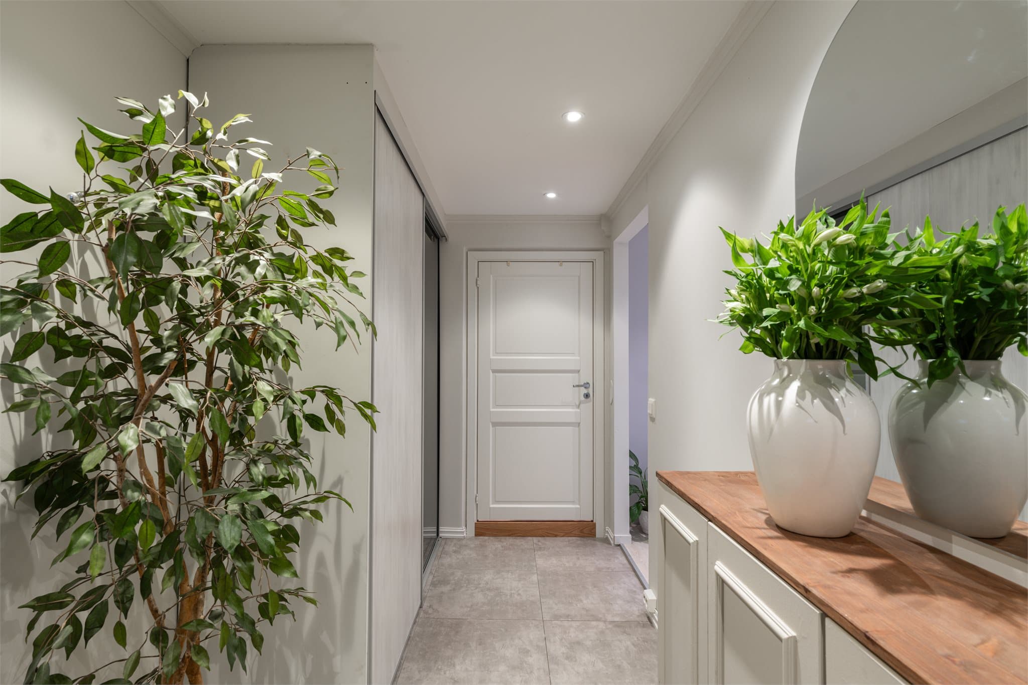 Innbydende entré med lyse overflater og god romfølelse. Skyvedørsgarderobeskapet gir praktisk oppbevaring og bidrar til et ryddig uttrykk.