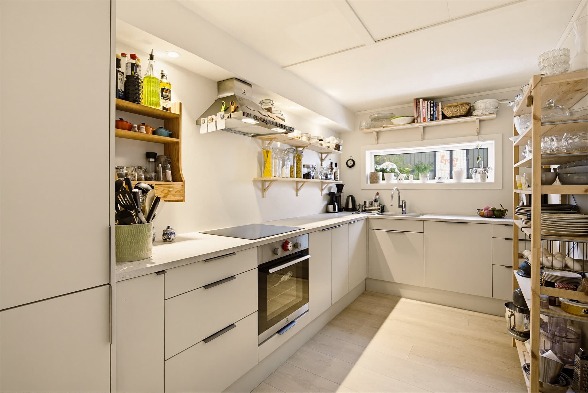 Moderne Epoq-kjøkken fra 2024 med glatte fronter, laminat benkeplate med nedfelt kum i rustfritt stål og integrerte hvitevarer.