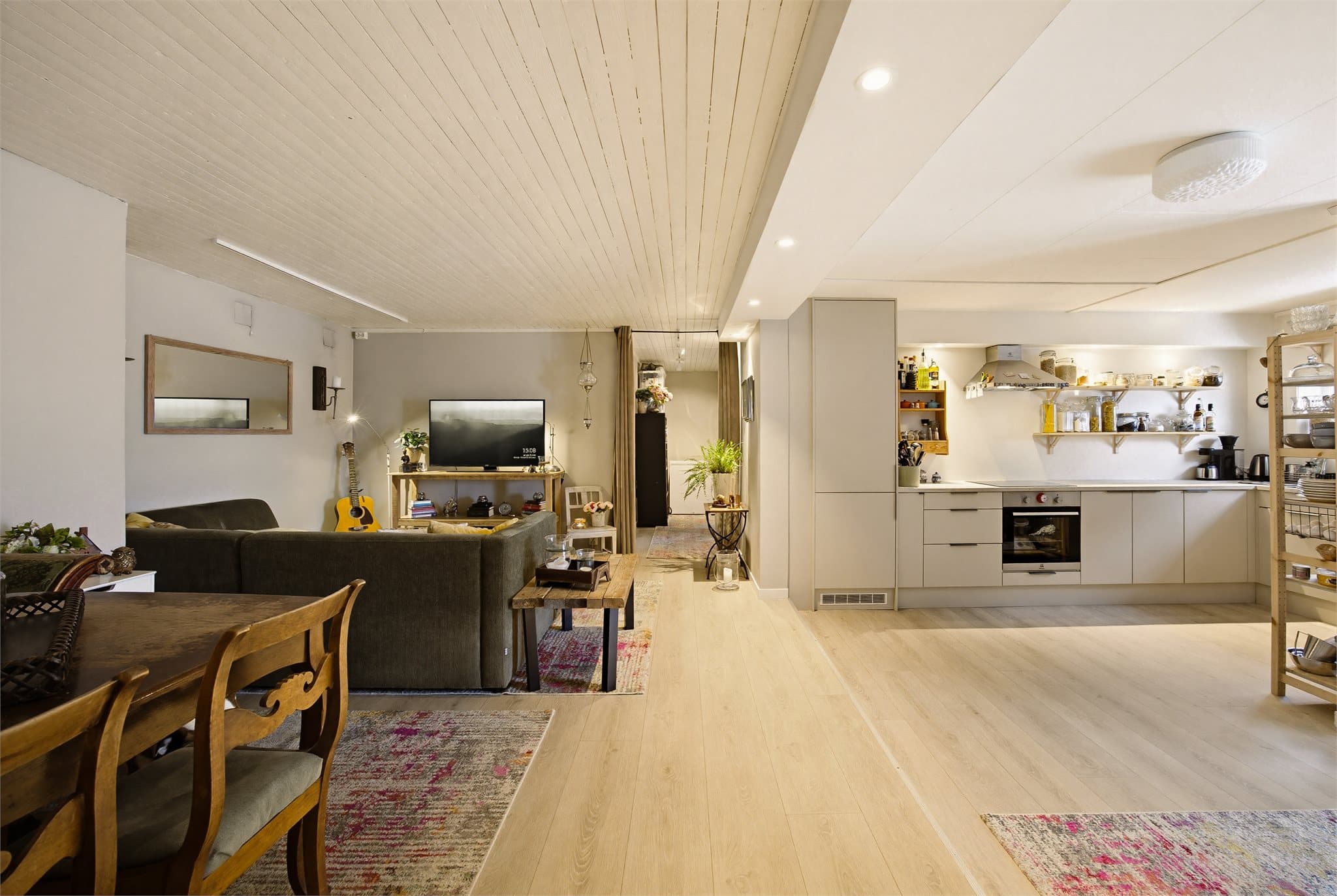 Åpen løsning mellom stue og kjøkken skaper god flyt og en lys, trivelig atmosfære i underetasjen.