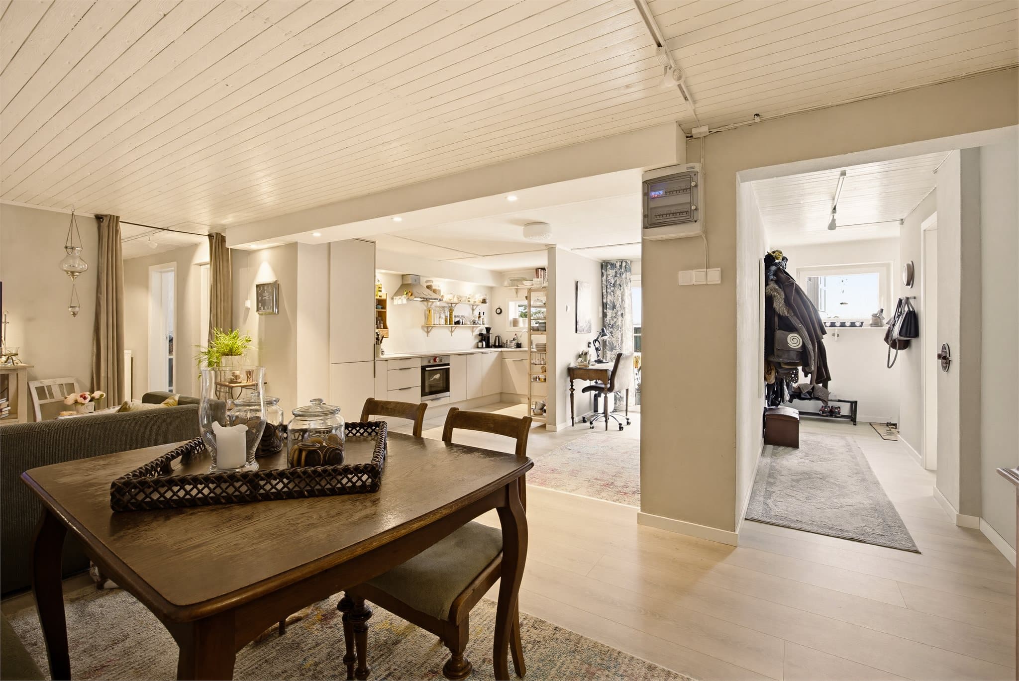 Rommet kan enkelt møbleres med både sofa-/TV-sone og spiseplass, med terrassedører som slipper inn rikelig med naturlig lys. Til høyre ser du enteén.