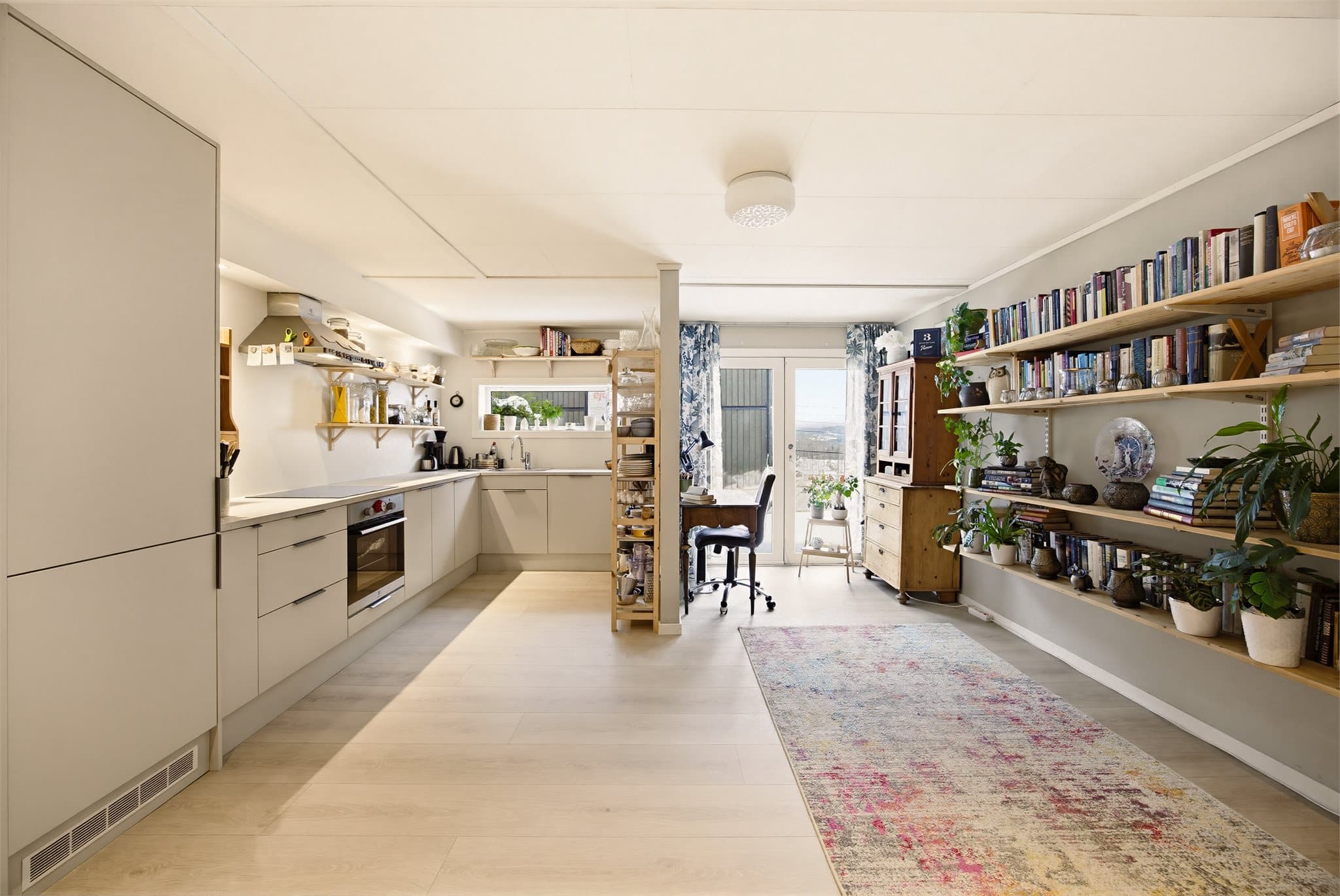 Underetasjen har stue og kjøkken i åpen sone, som skaper en sosial og luftig romfølelse. Laminatgulv og store vindusflater bidrar til et lyst og trivelig miljø.