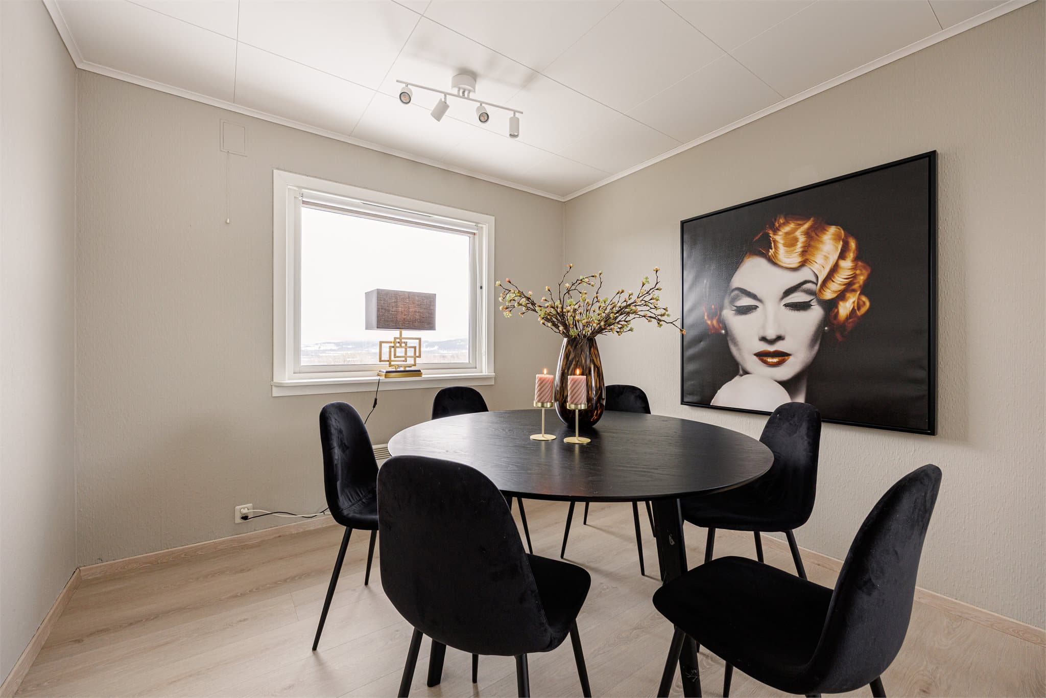 Malte overflater i en lun beige tone kombinert med laminatgulv i samme stil som kjøkkenet gir rommet et helhetlig og harmonisk uttrykk.