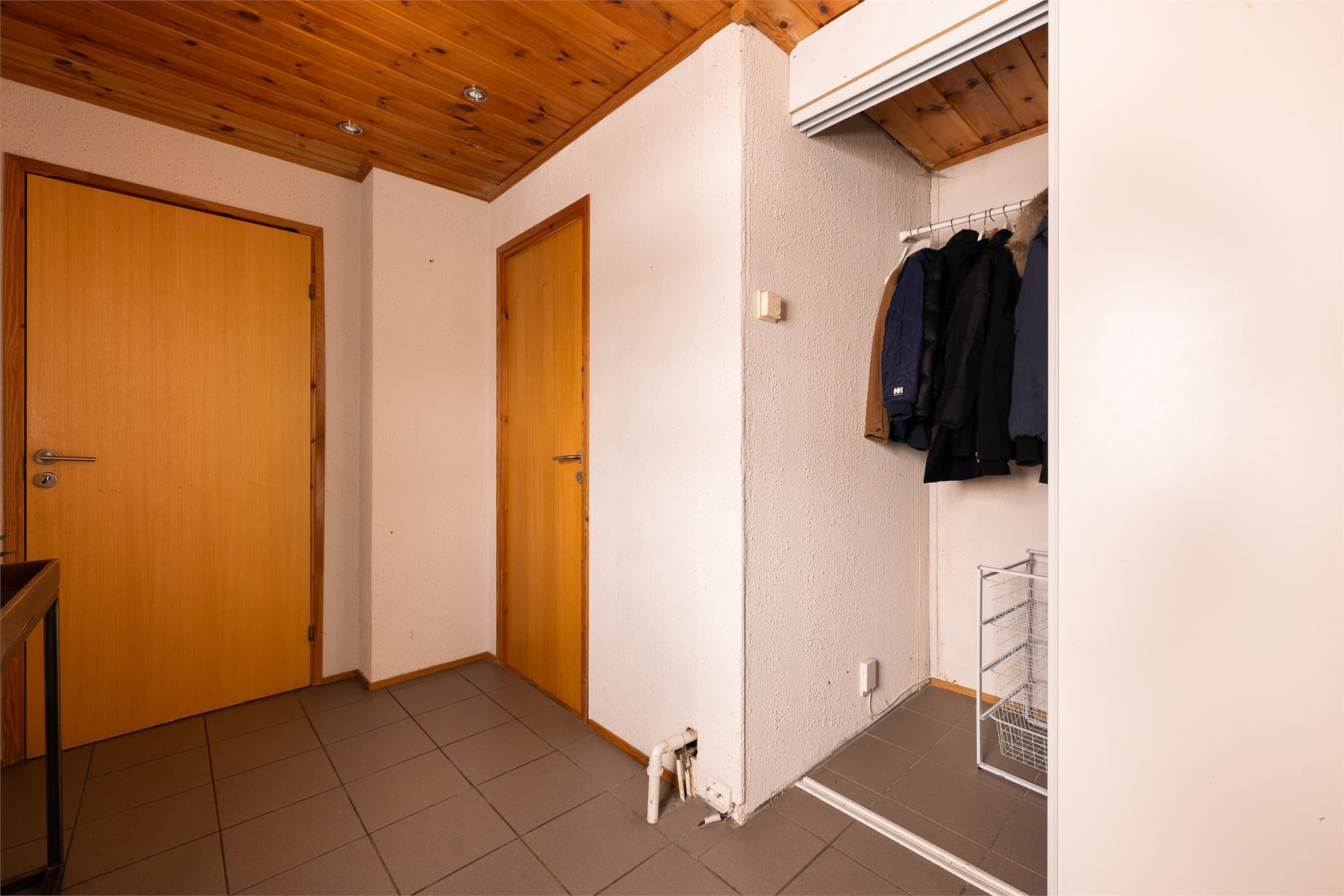 Entreen har fliser på gulv og det er skyvedørsgarderobe.