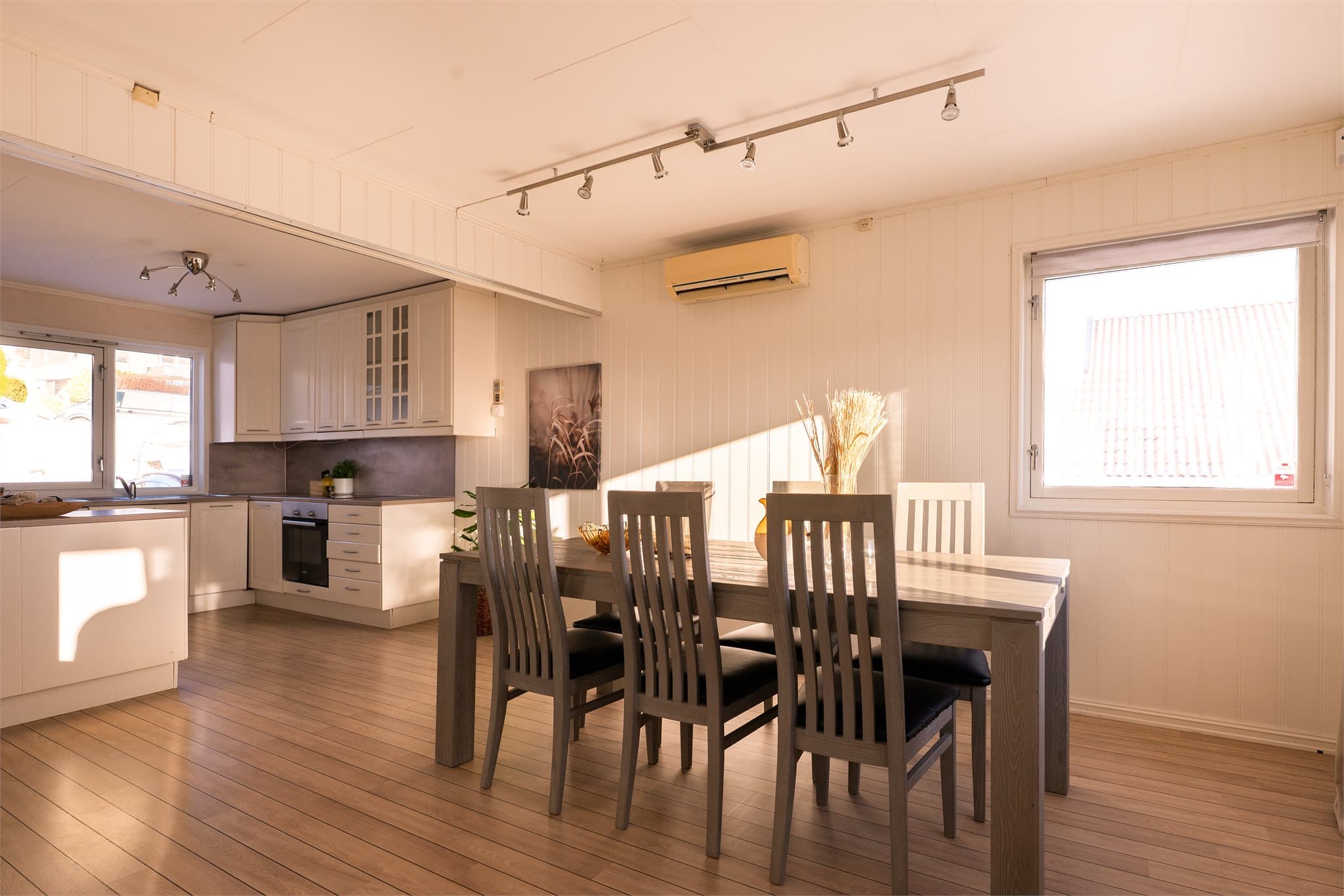 Oppholdsrommet har lysmalte veggflater og laminat på gulv.