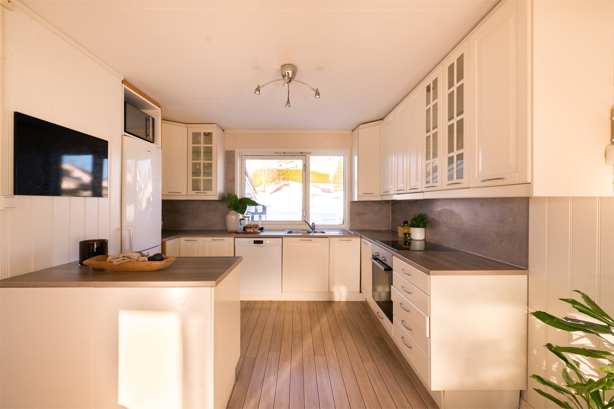 Innredningen har en praktisk utforming som gir godt med benkeplass og oppbevaring i takhøye skap samt skuffer.