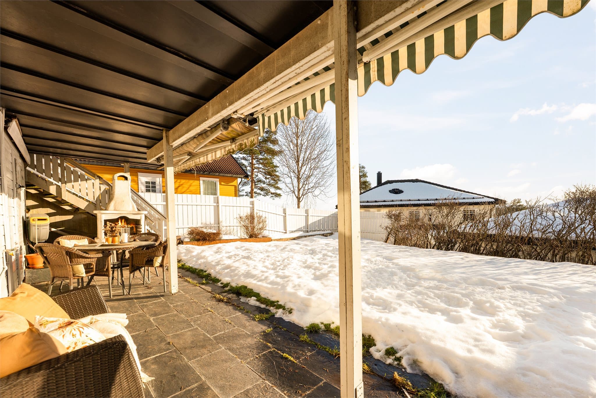 Fra det ene soverommet har man utgang til overbygd uteplass og hage.