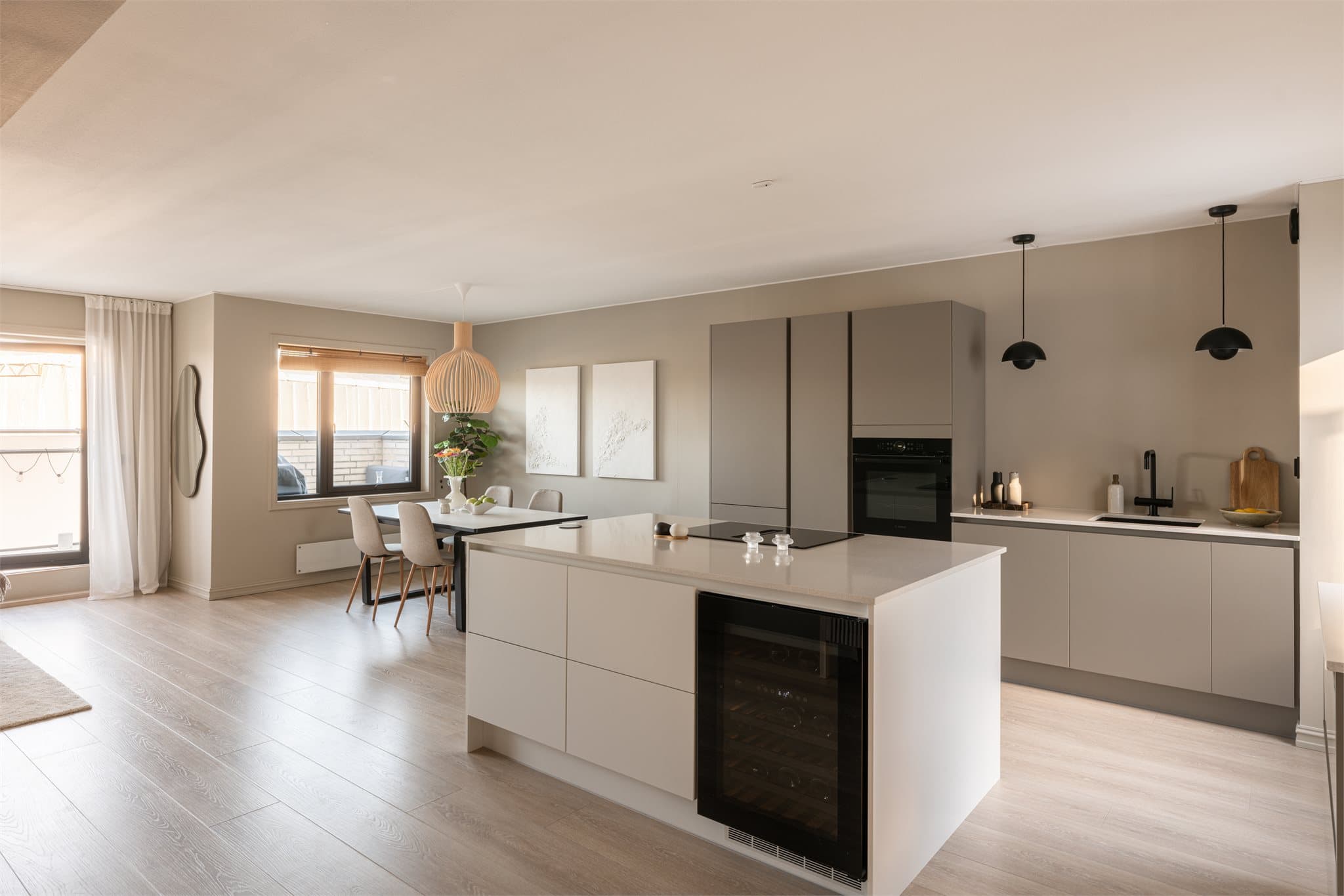 Leilighetens sosiale sone har en åpen løsning mellom stue og et rålekkert, velutstyrt HTH-kjøkken.