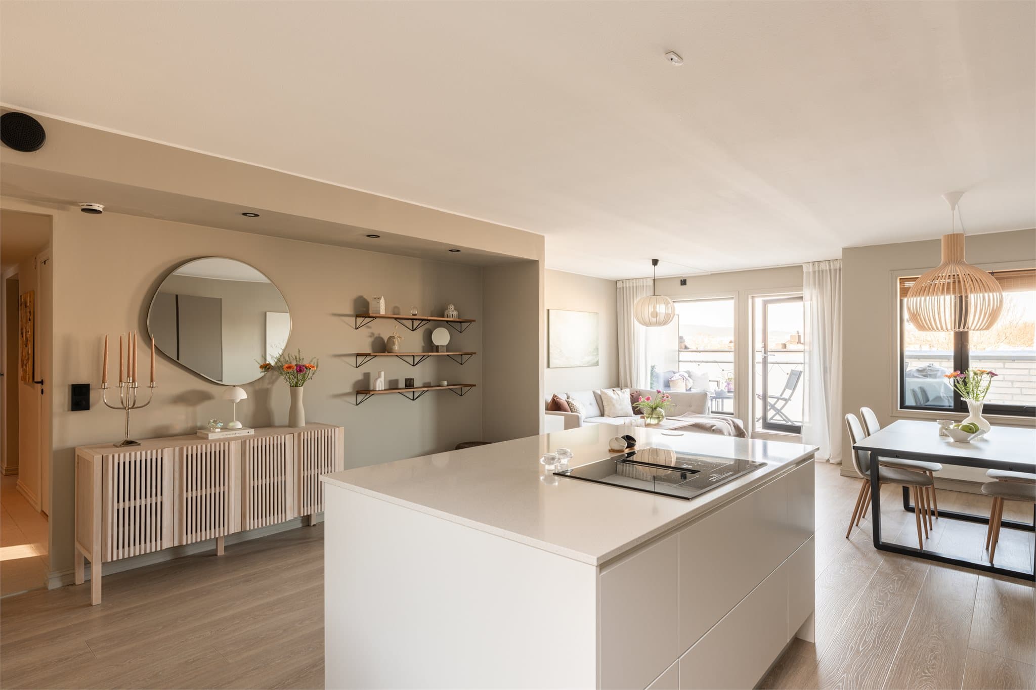 Den åpne planløsningen skaper en luftig og sosial atmosfære i boligens hovedrom, perfekt for hyggelige middager og samlinger med venner og familie.