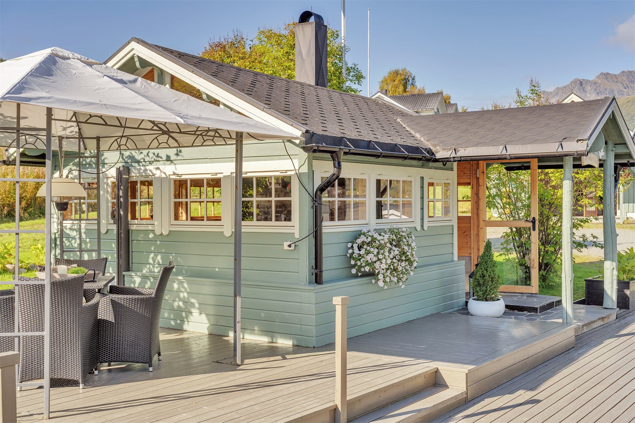 Lysthuset og markterrassen danner et lunt og samlet uteområde på eiendommen.