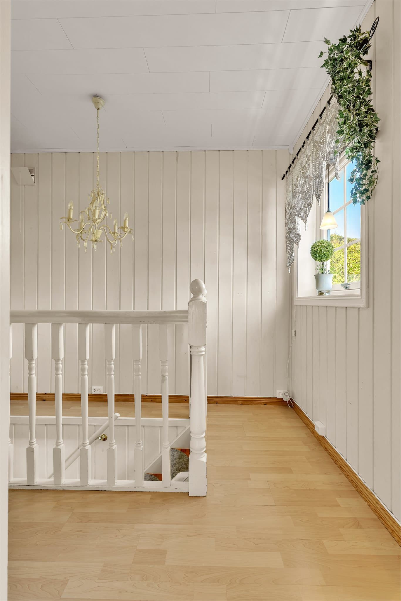Hvitmalt tretrapp forbinder første etasje med kjelleretasjen.