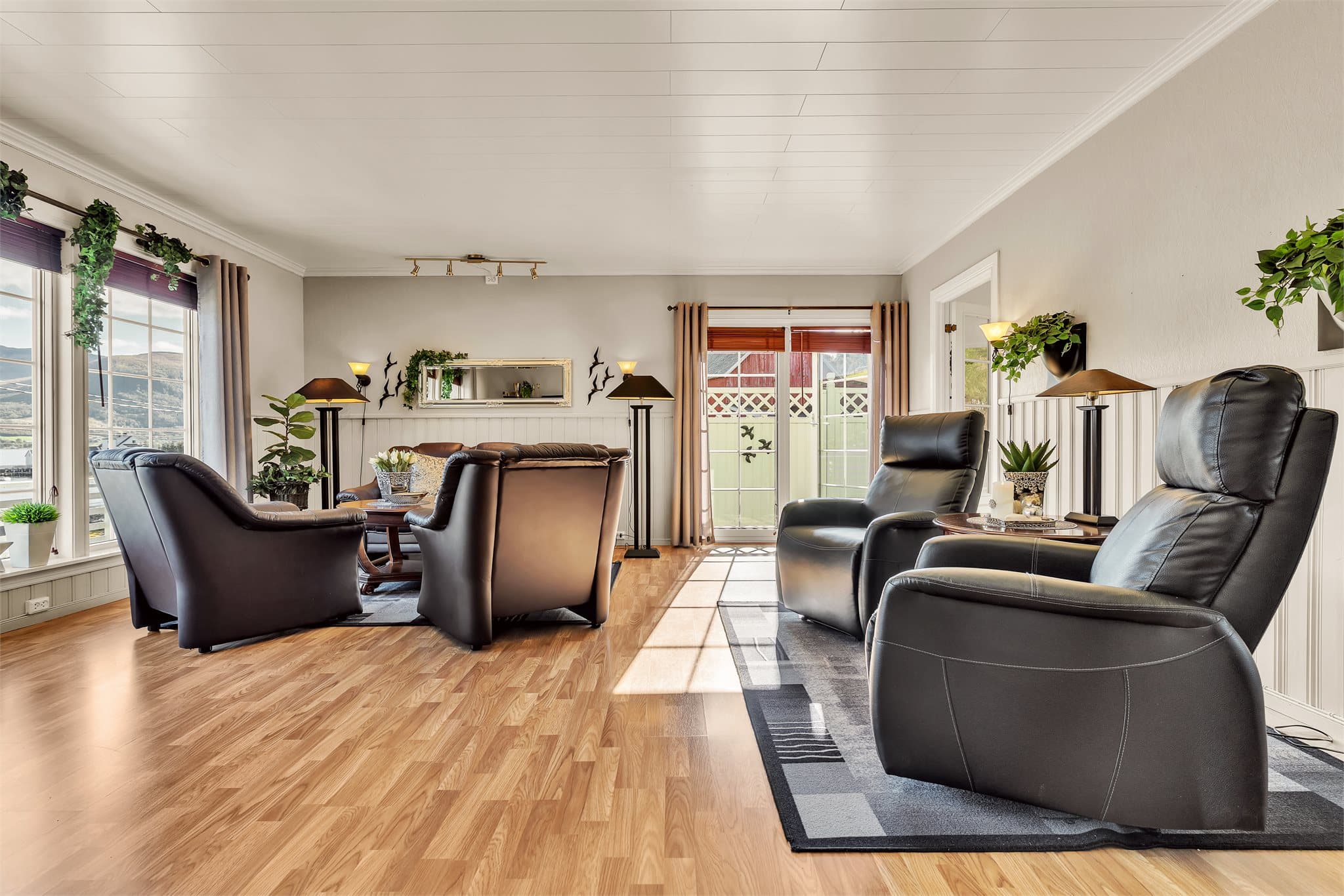 Stuen har romslig utforming med plass til flere sittegrupper og gjennomgående lys.