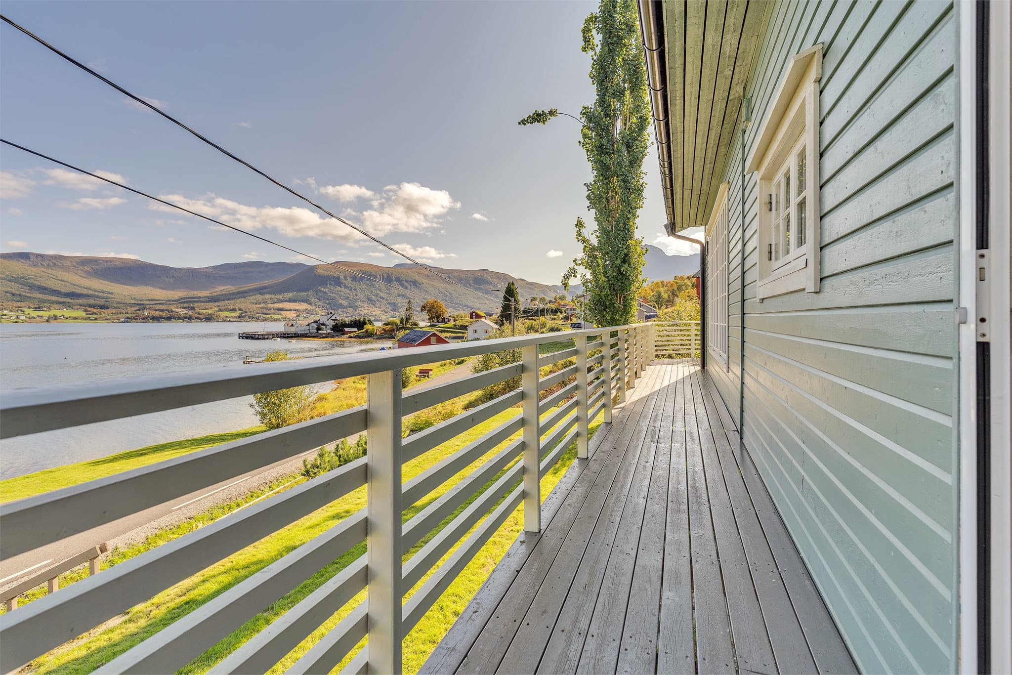 Verandaen strekker seg langs fasaden og vender direkte ut mot fjorden.