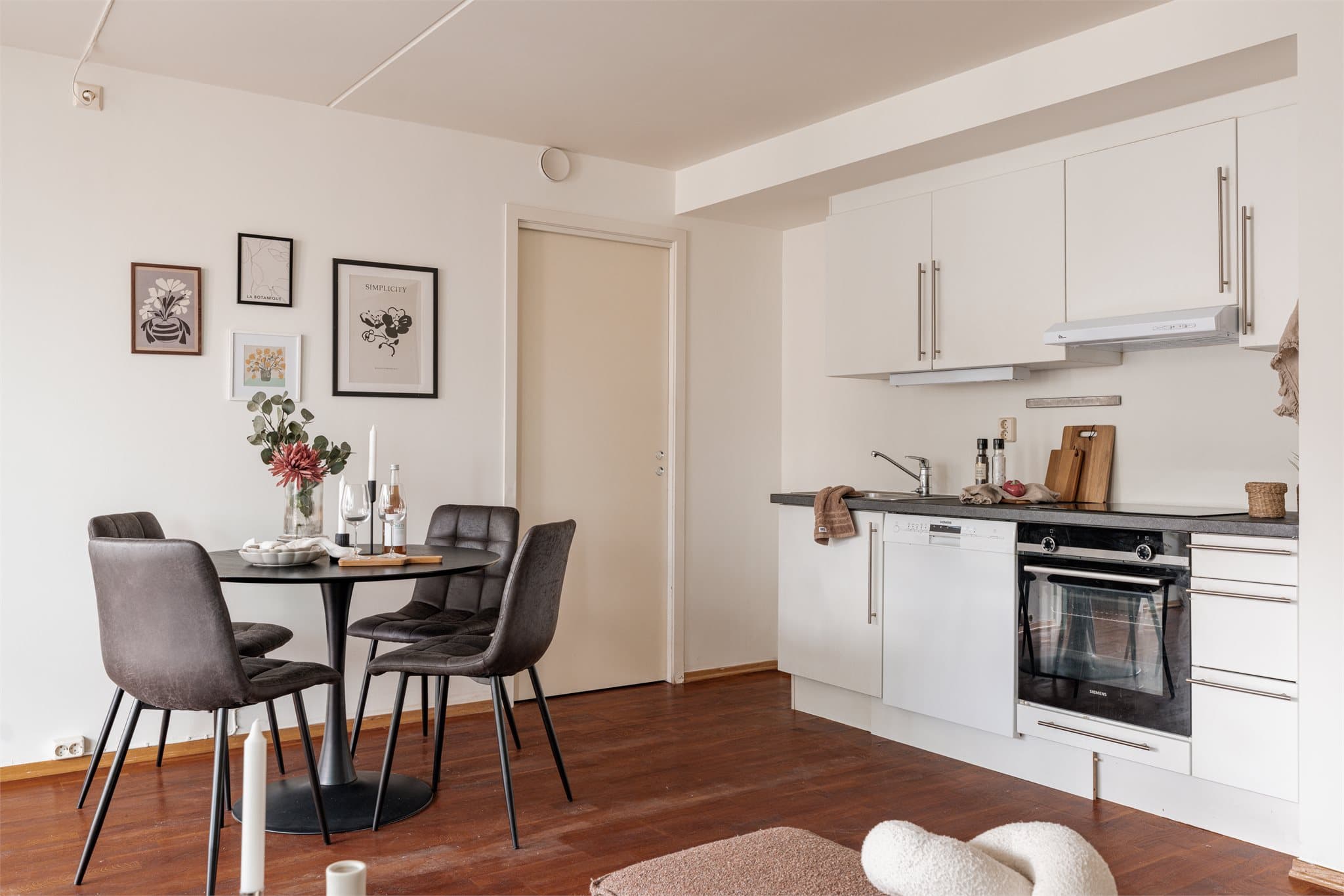 Kjøkkenet er praktisk innredet med glatte, hvite fronter og mørk laminatbenkeplate.