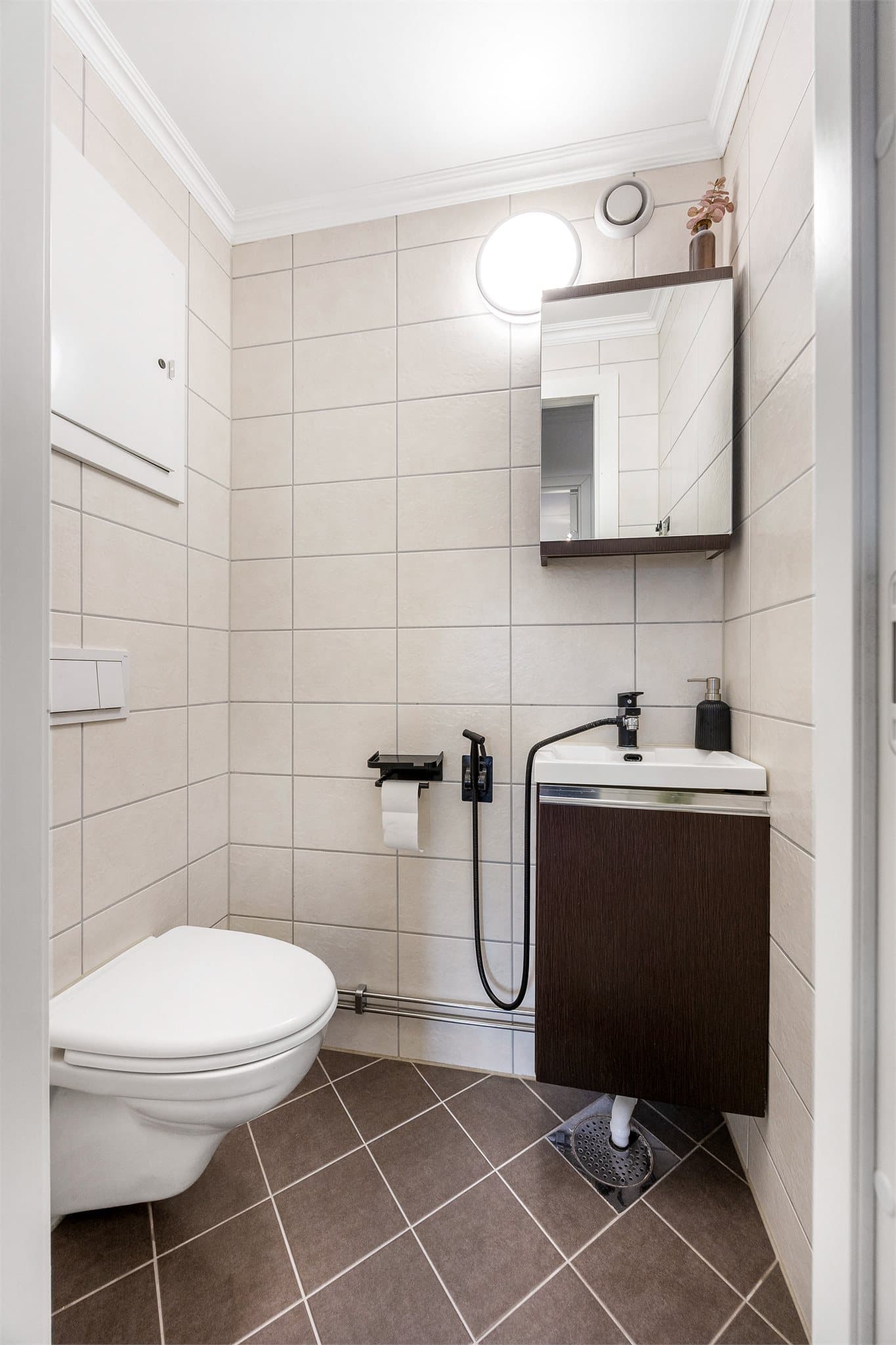 Leiligheten har et praktisk, separat toalettrom med vegghengt klosett og servant.