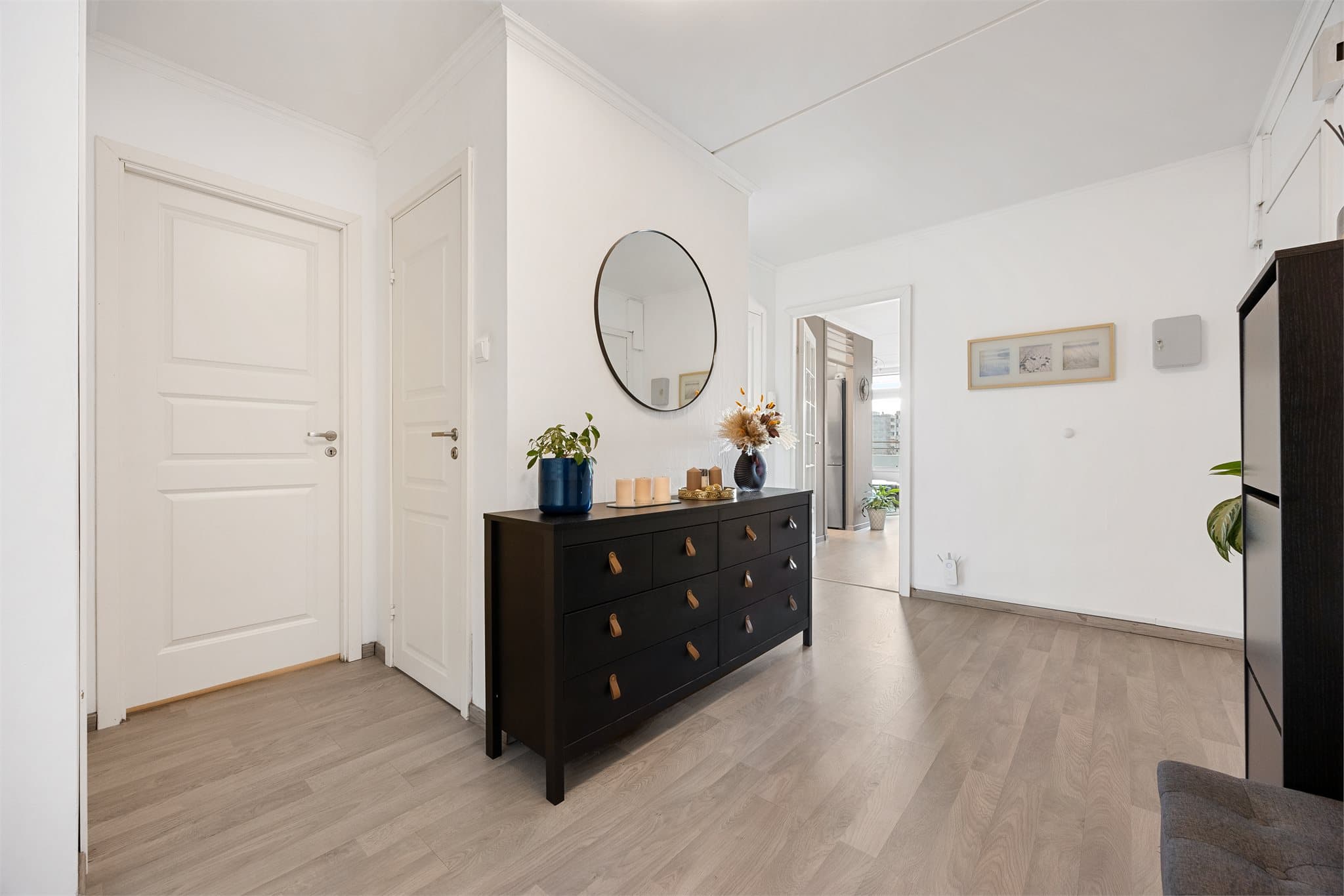 Romslig entré som fungerer som et bindeledd mellom leilighetens rom.