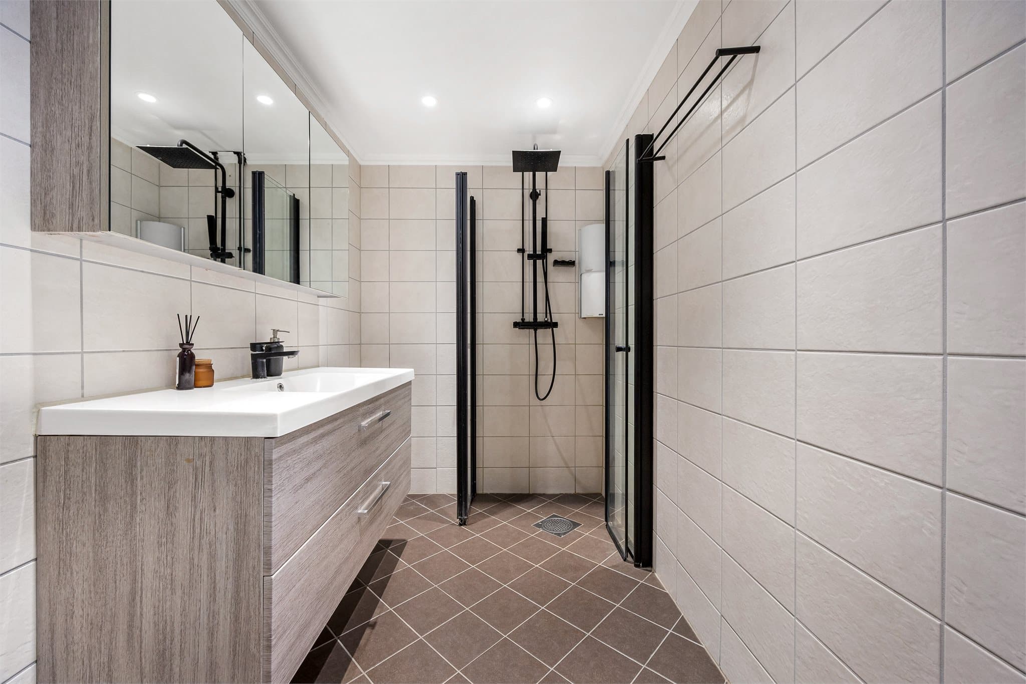 Dusjnisje med innfellbare dører i herdet glass gir en arealeffektiv løsning.