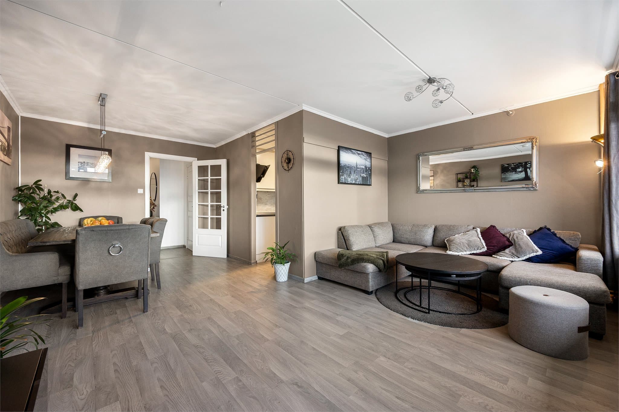 Gjennomgående laminatgulv og malte flater gir et helhetlig inntrykk.