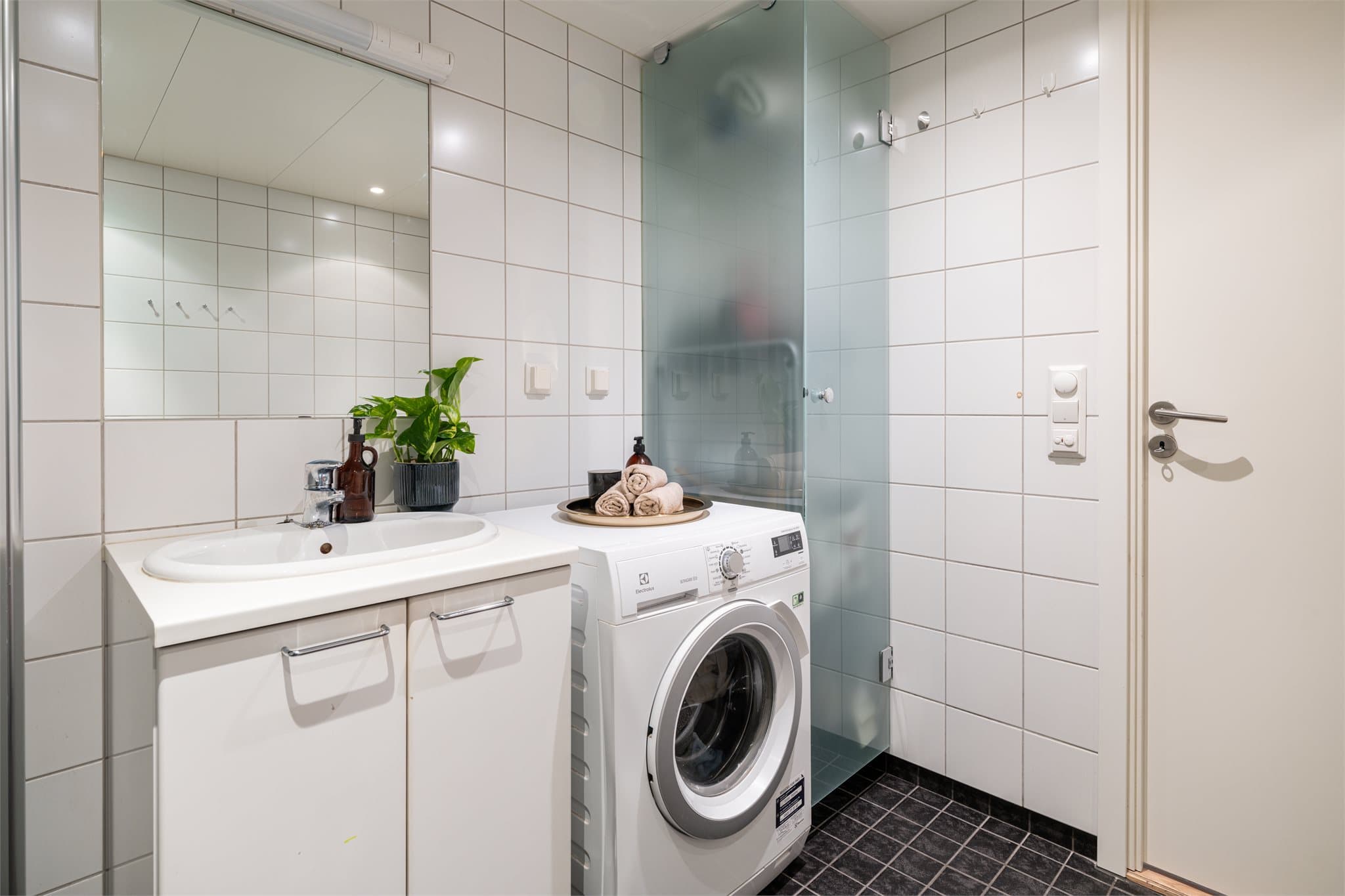 Badet har servant med underskap og et eget integrert tørkeskap.