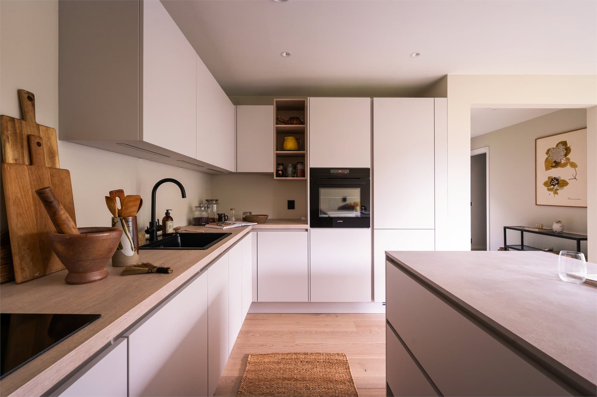 Dette er et moderne kjøkken med glatte fronter, kompaktlaminat benkeplate og integrerte hvitevarer.