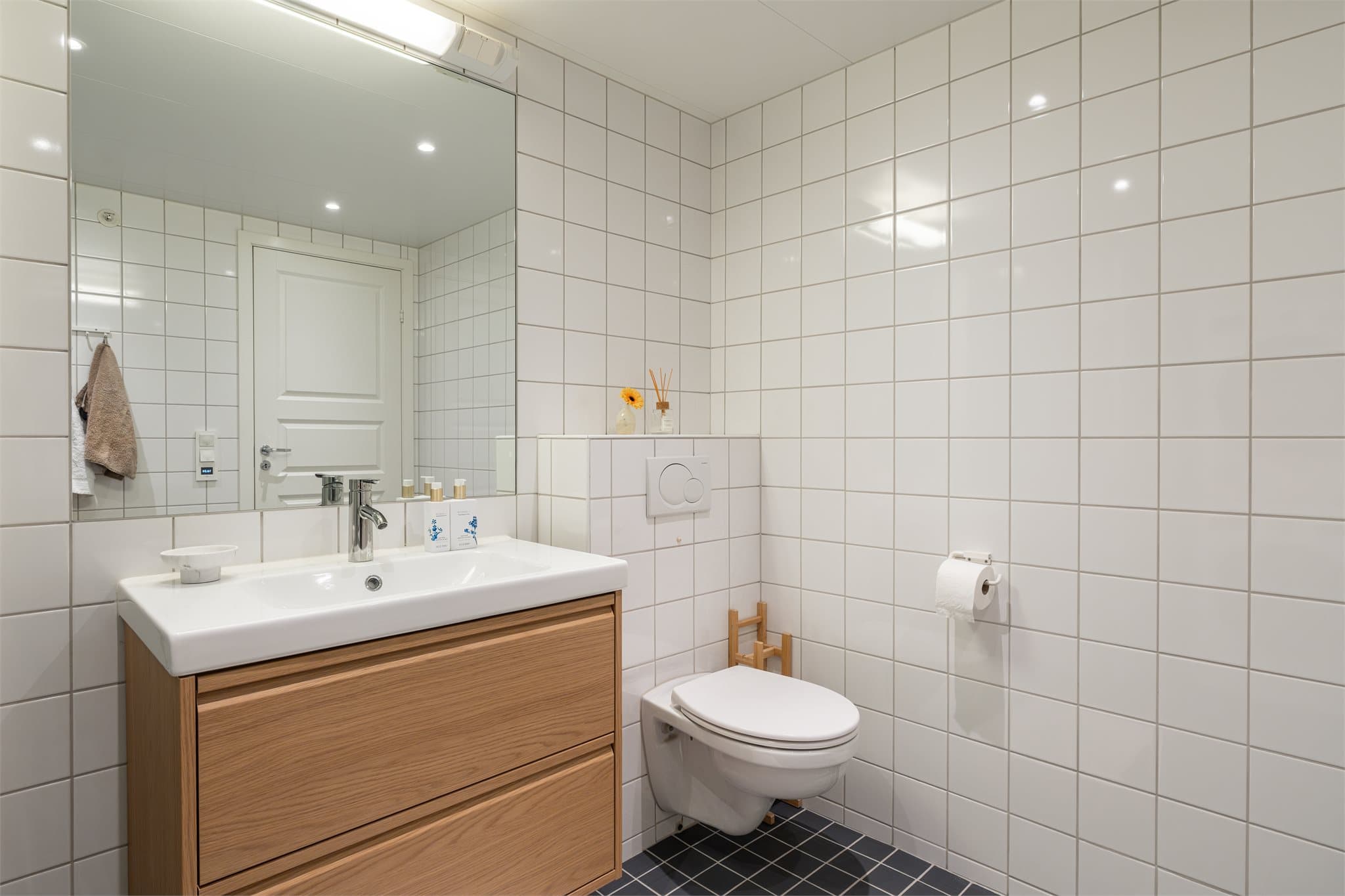 Flislagte overflater, gulvvarme og vegghengt toalett som gir et ryddig uttrykk