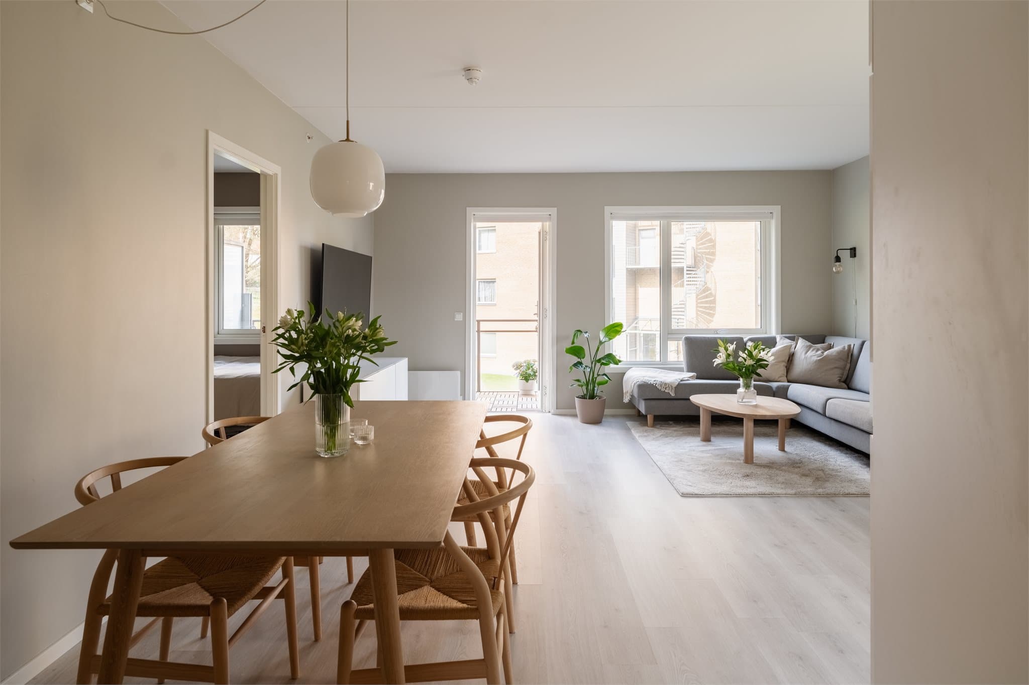Den åpne løsningen mellom stue og kjøkken gir en sosial og luftig atmosfære, med god plass til både spisebord og sofagruppe.
