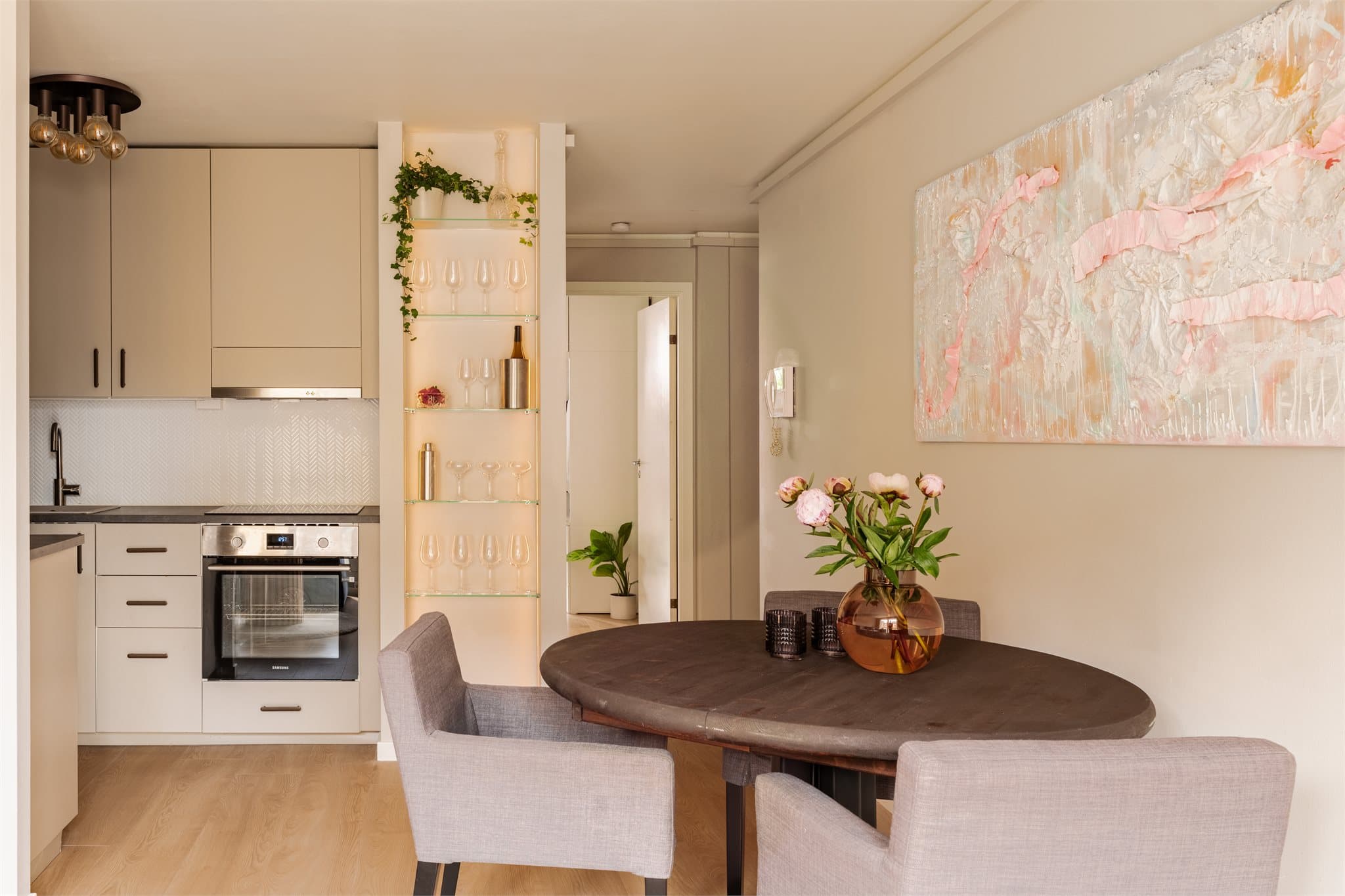 En belyst glasshylle skaper et elegant detalj, og gir oppbevaringsmuligheter.