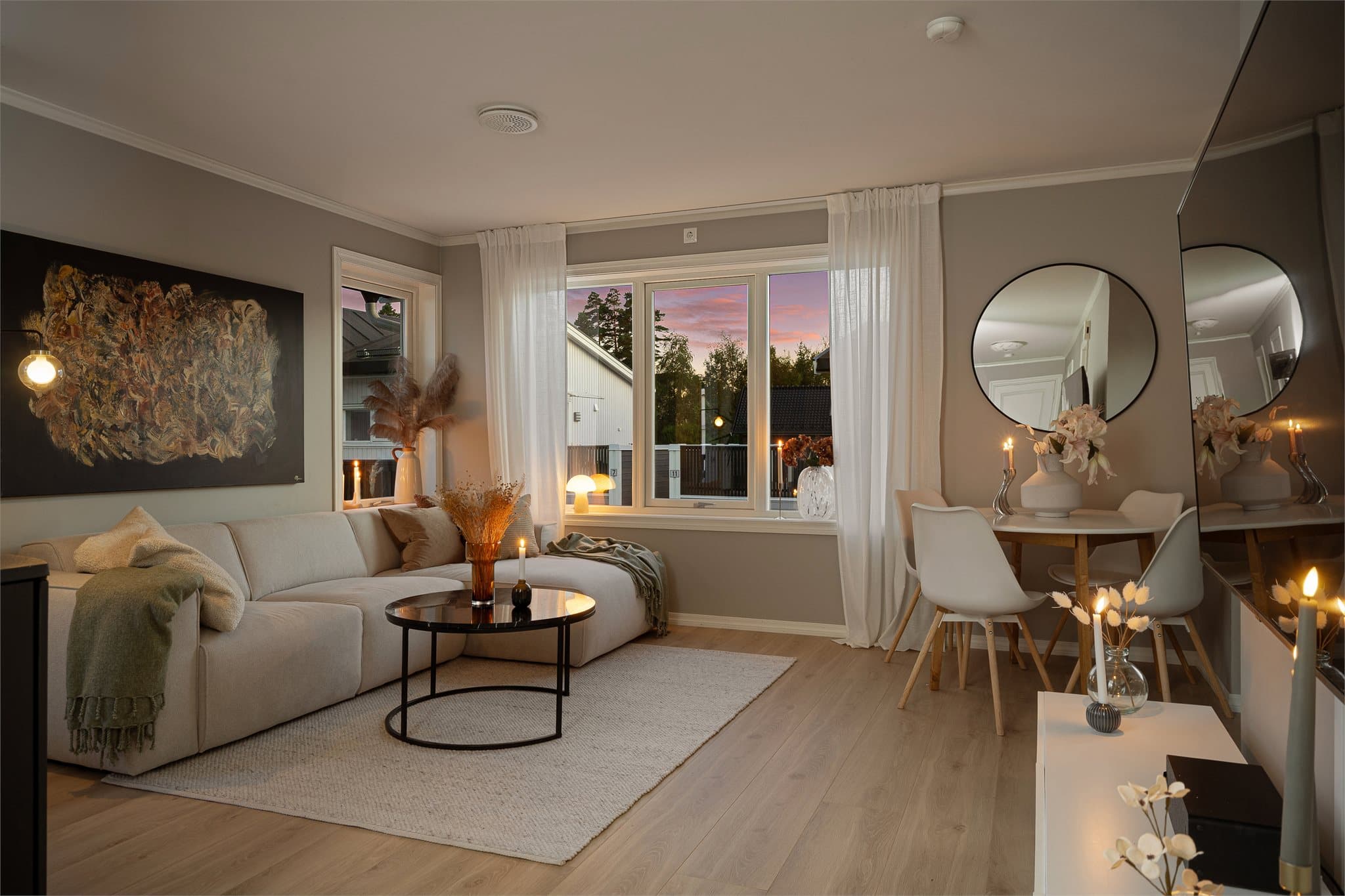 Lys og luftig stue med store vindusflater, moderne fargevalg og god plass til både sofakrok og spisebord.